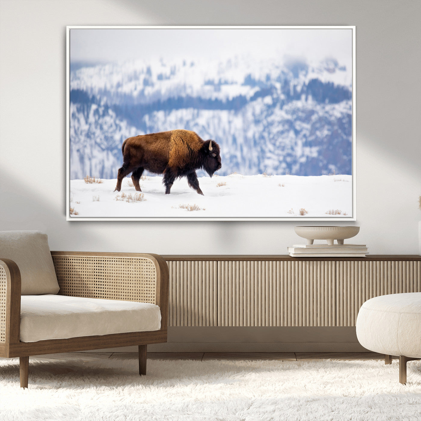 A lone bison walks across snowy ground with blue-toned mountain range behind, ideal for rustic or western farmhouse interiors.