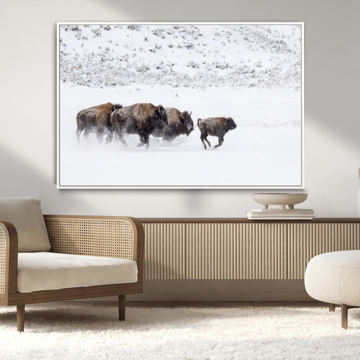 Bison herd running through a snowy open field with mountain backdrop, perfect for rustic or western-themed wall decoration.