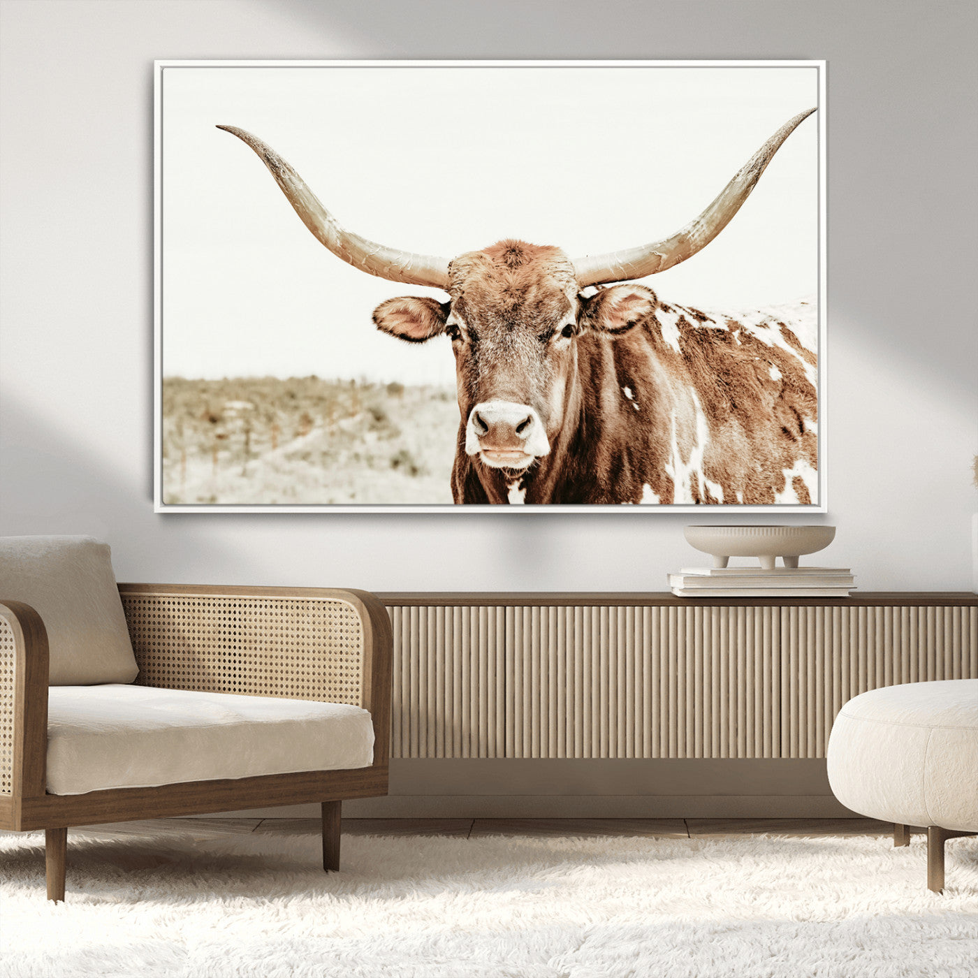 A Texas longhorn bull with wide horns, standing in a dry field under soft light, ideal for rustic farmhouse or western-themed interiors.