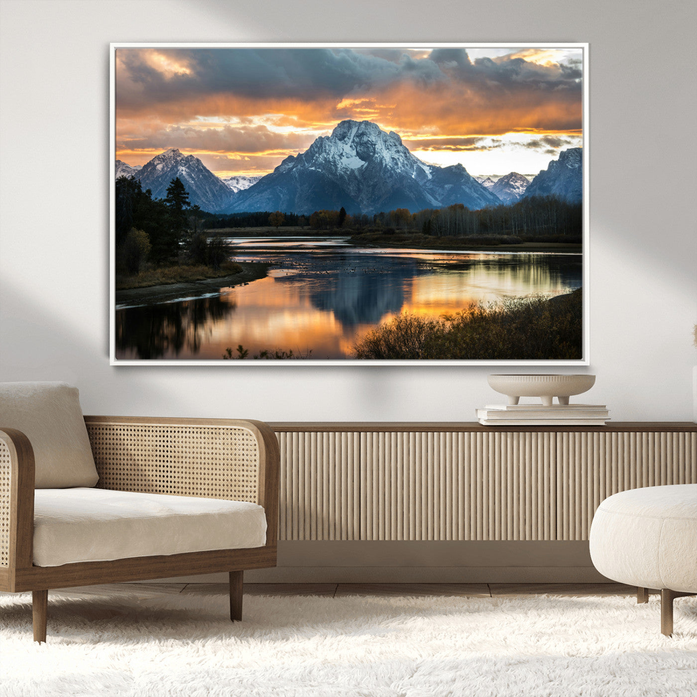 Snow-capped mountains reflecting in a calm lake at sunset, with a dramatic golden sky creating a breathtaking wilderness scene.