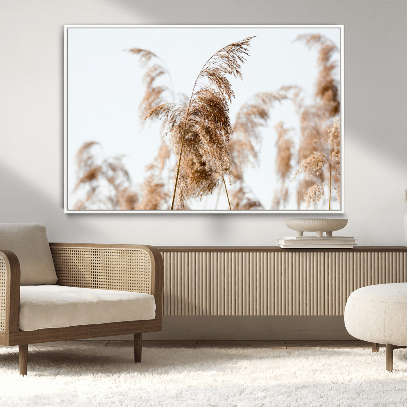 Close-up of pampas grass swaying in the wind against a soft white sky, creating a neutral and minimalist botanical aesthetic.
