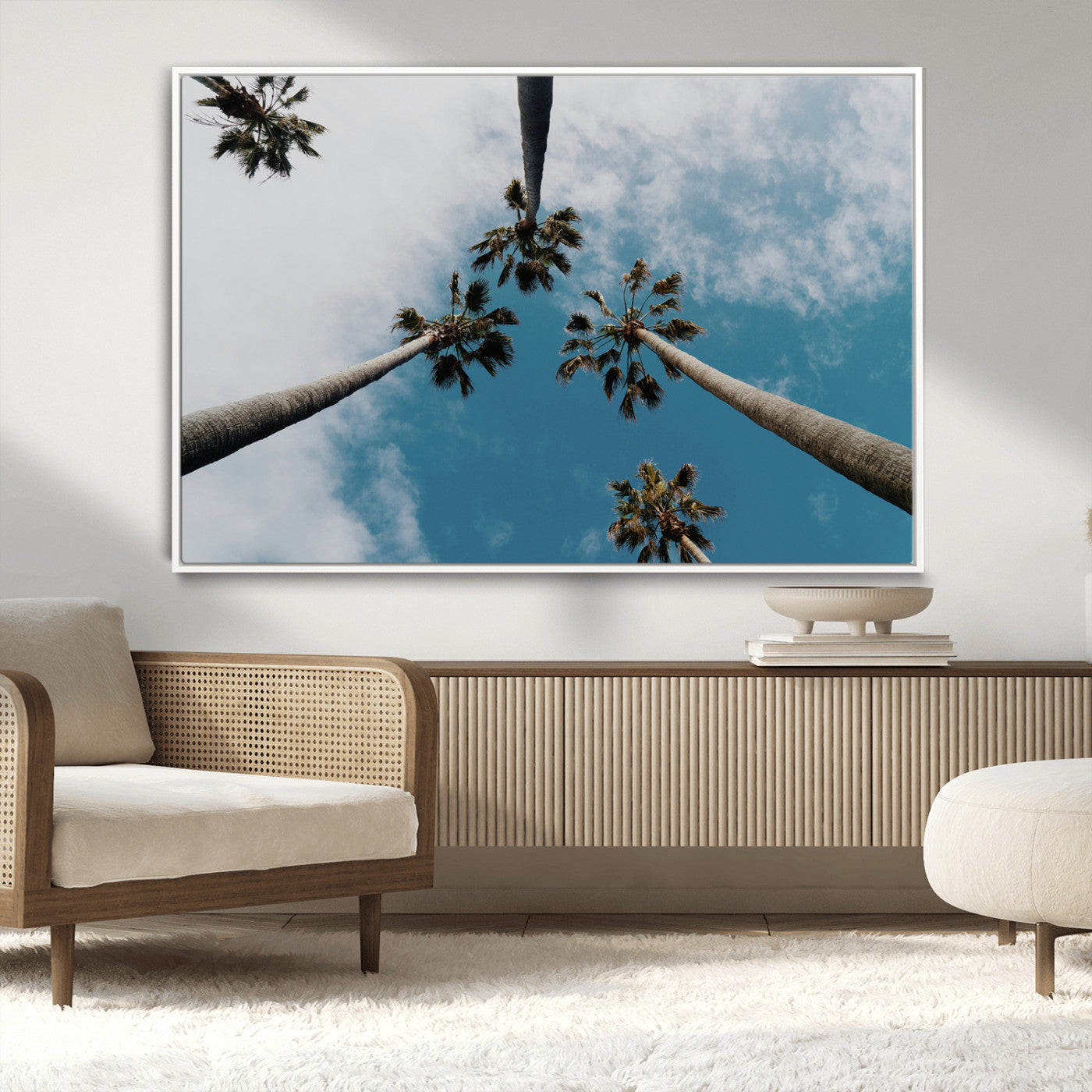 Looking up at tall palm trees against a bright blue sky with scattered clouds, creating a tropical and airy atmosphere for modern home decor.
