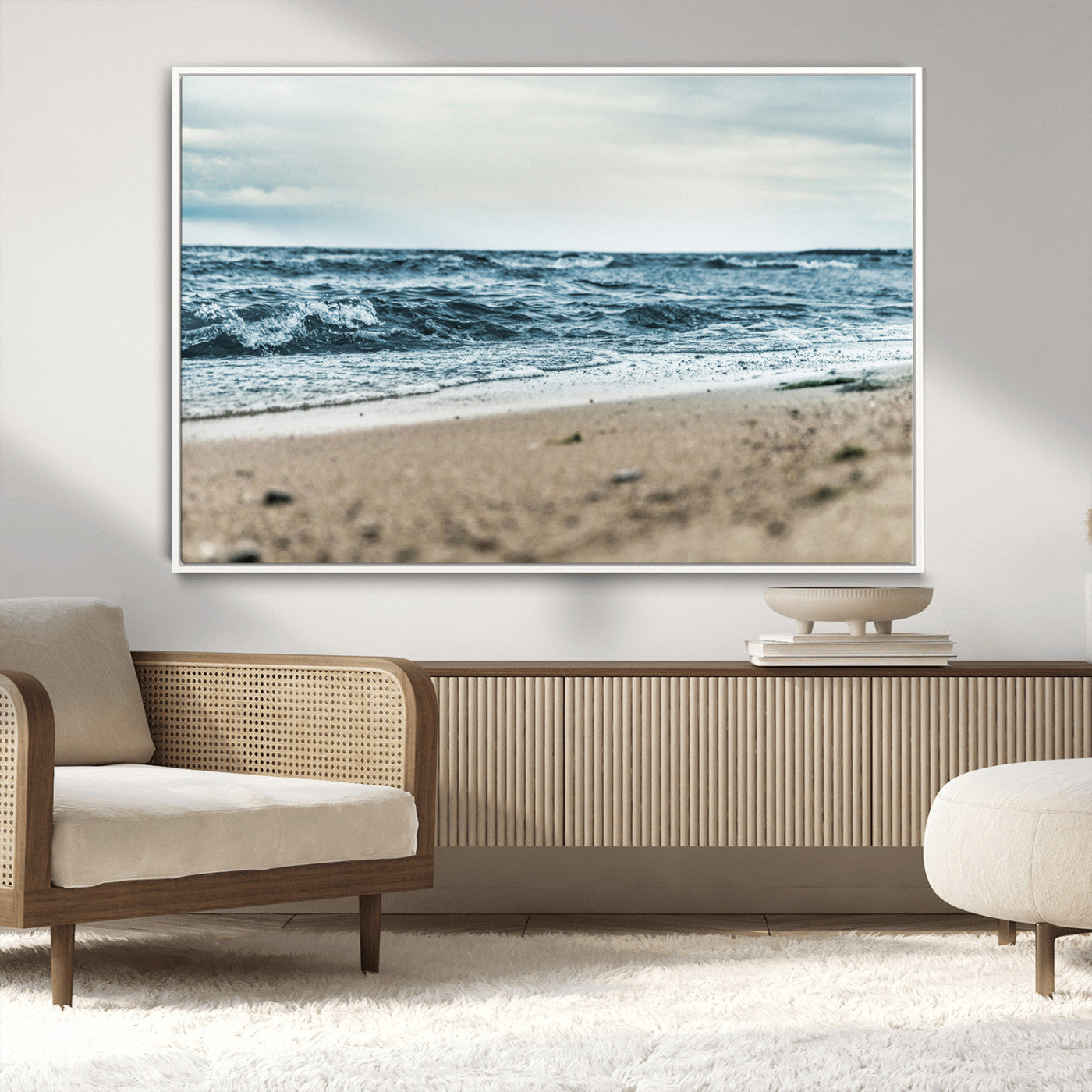 A moody ocean scene with gentle waves washing onto a sandy beach under a cloudy sky, creating a peaceful and coastal atmosphere.