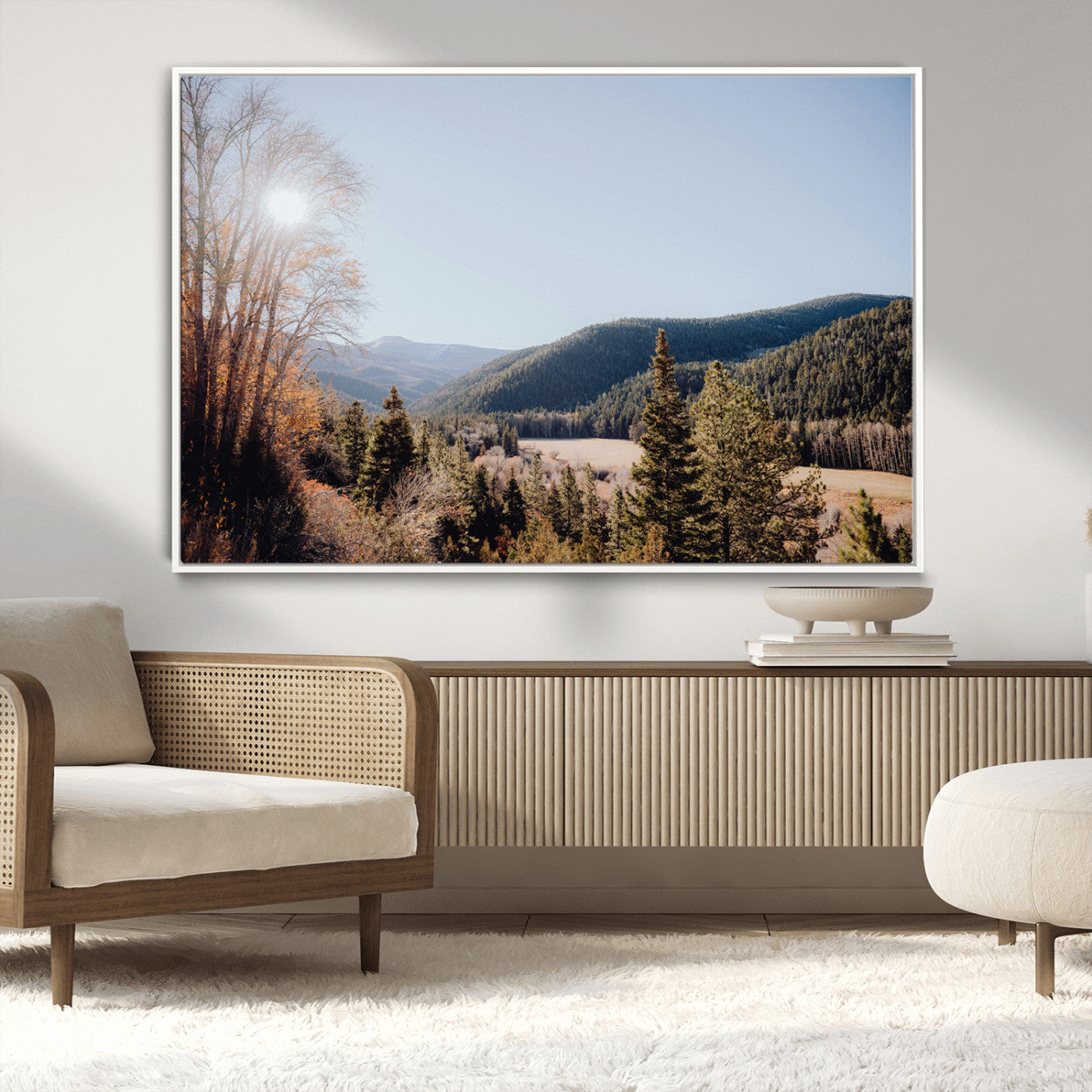 A scenic mountain valley with pine trees and autumn foliage under a clear sky, bathed in golden sunlight, creating a peaceful and rustic landscape.