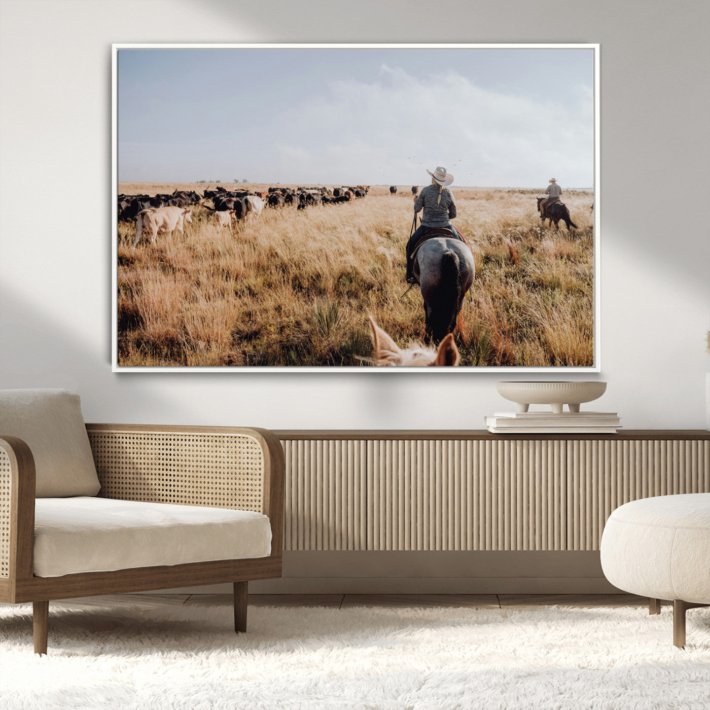 A cowboy and cowgirl on horseback herding cattle through golden grasslands, capturing a rustic and authentic Western ranch lifestyle.