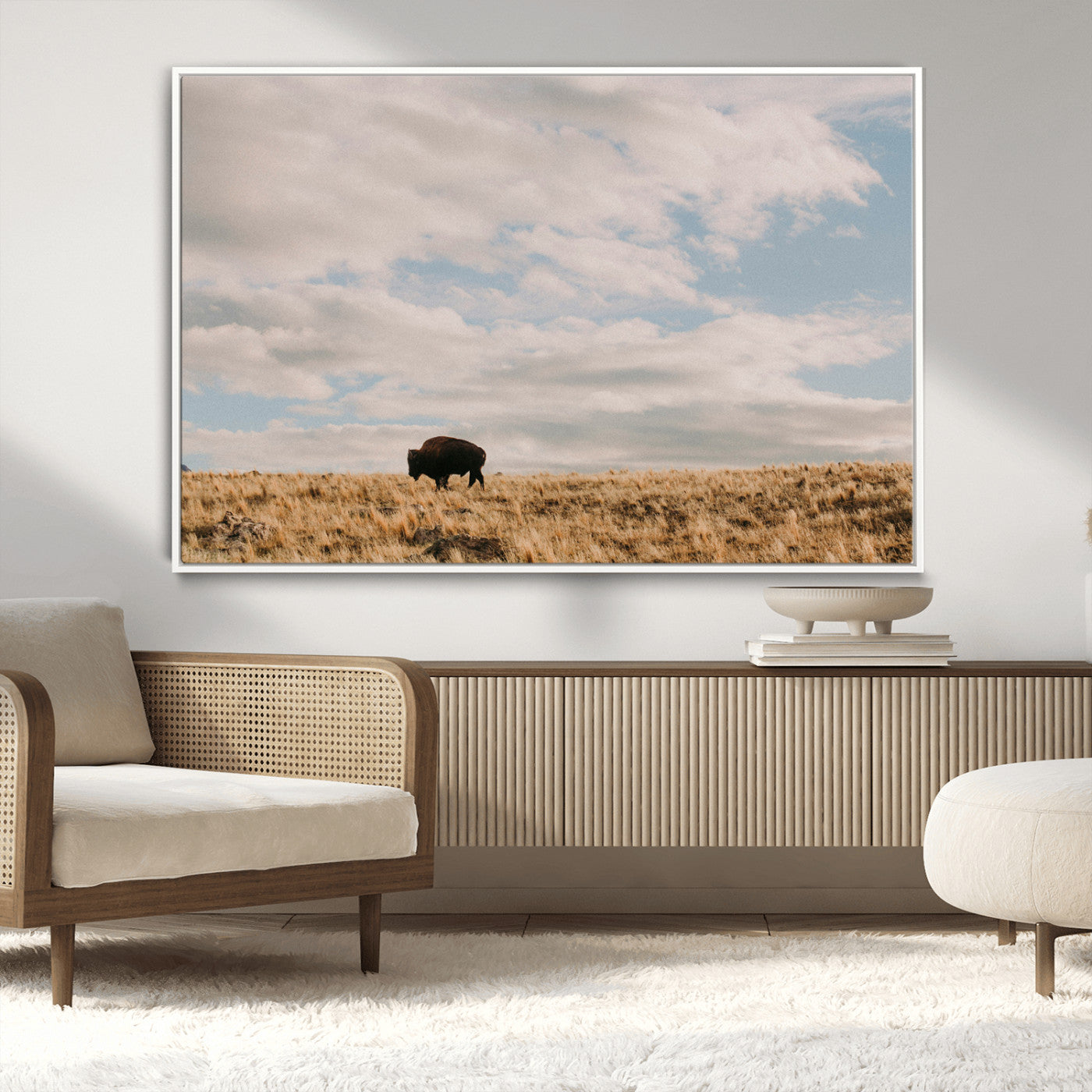 A solitary bison walking across a golden prairie under a vast, cloud-filled sky, evoking a peaceful, rustic western landscape for home decor.