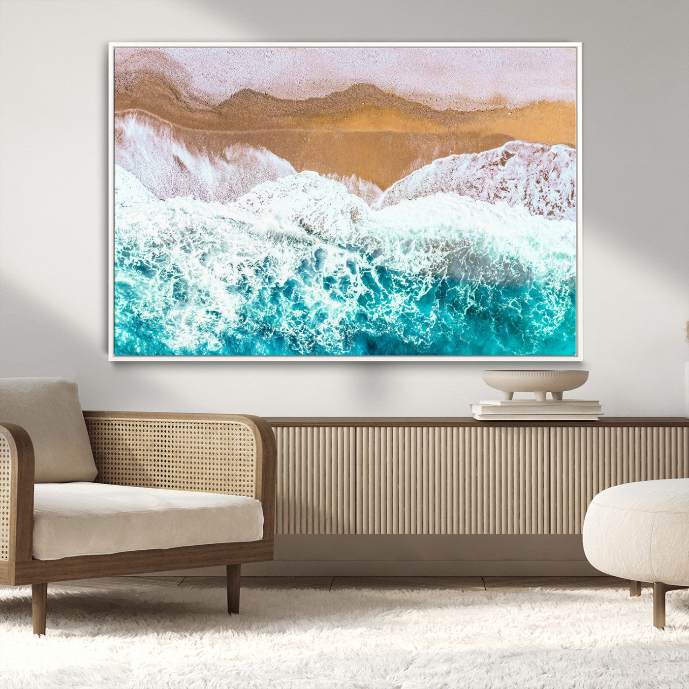 Aerial view of ocean waves crashing onto a sandy beach, with turquoise water and foamy white surf, creating a serene coastal aesthetic for home decor.