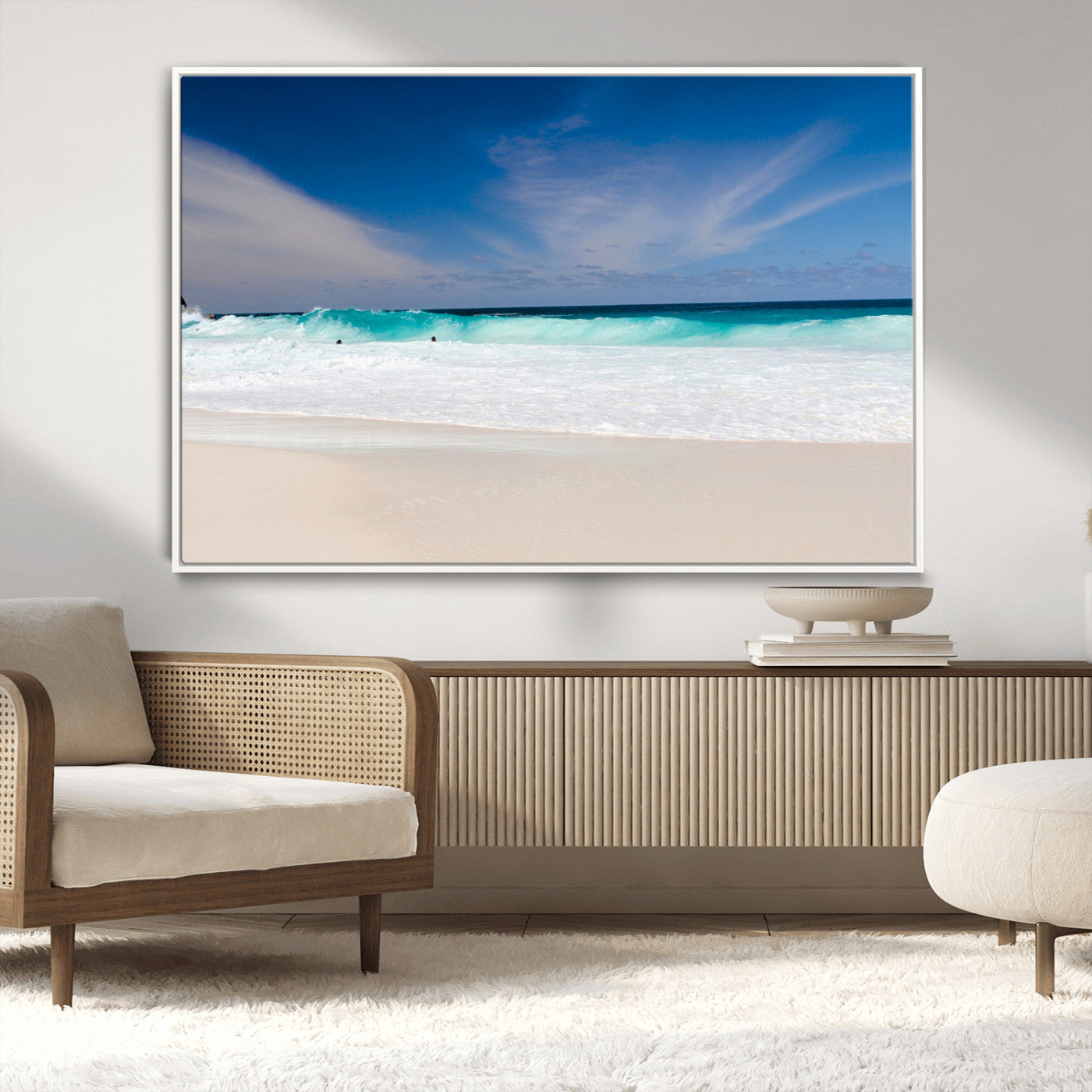 Turquoise waves crash onto a pristine white sand beach under a vivid blue sky with wispy clouds, creating a peaceful and refreshing coastal scene.