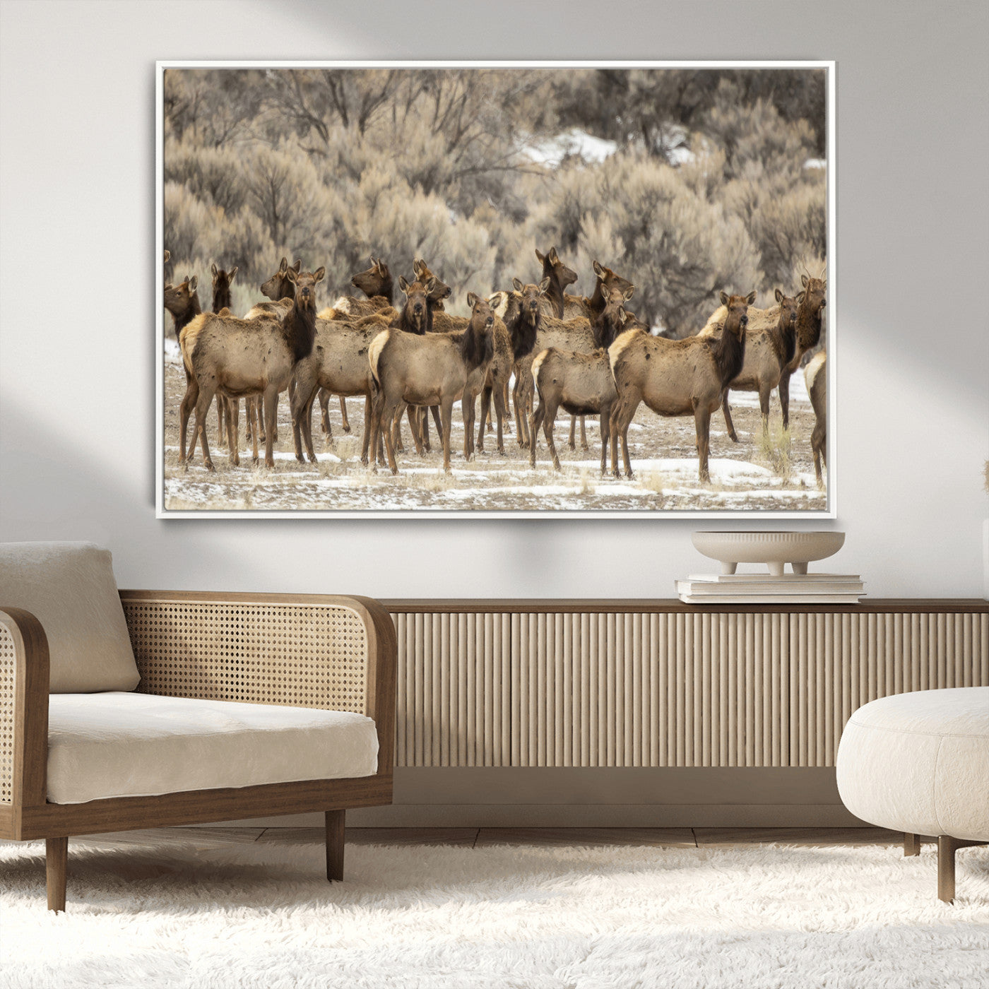 A stunning wall art canvas print featuring a large herd of elk standing together in a natural winter landscape with muted earthy tones and soft background foliage, perfect for rustic or nature-inspired home decor.