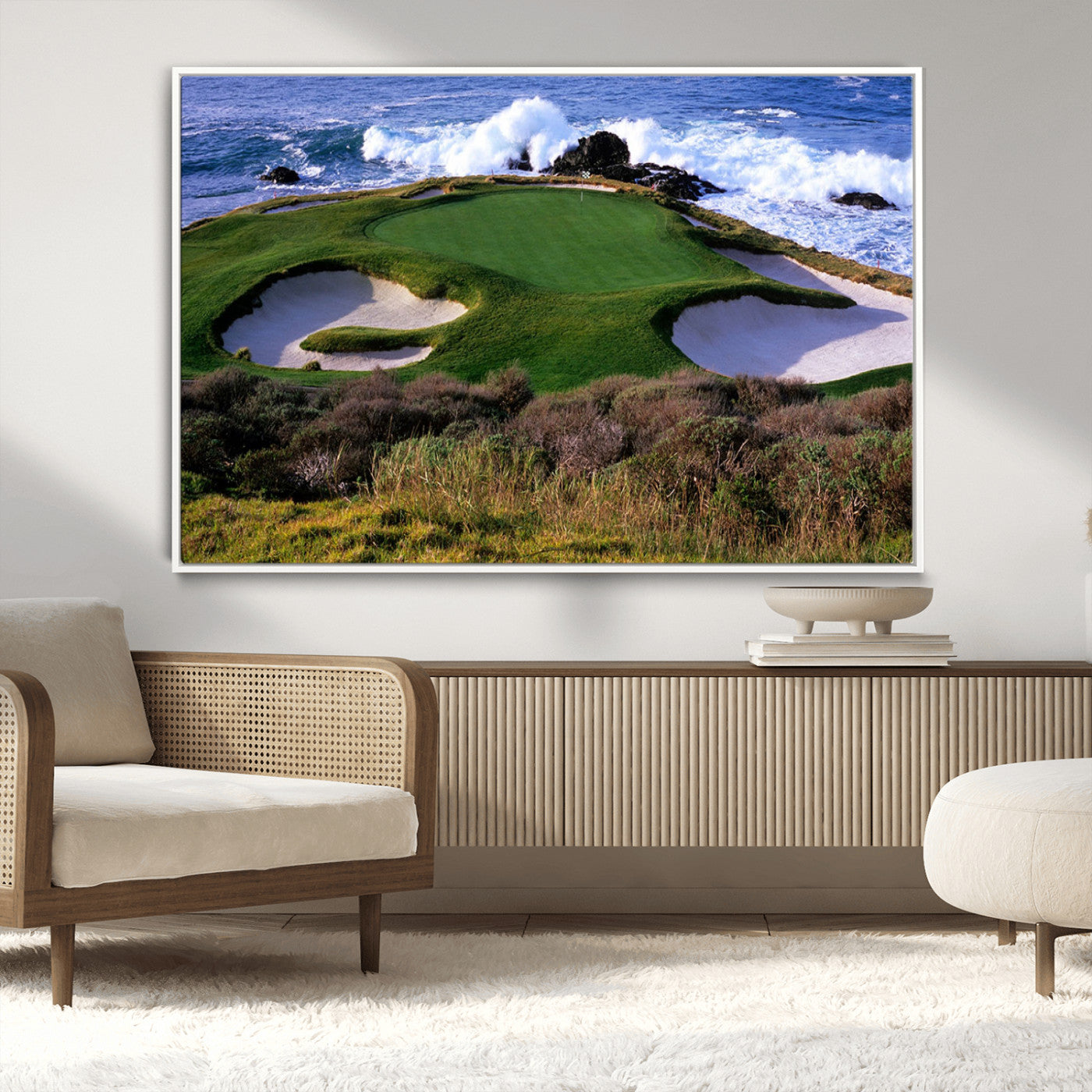 A scenic golf course located by the ocean, featuring a well-manicured green surrounded by sand traps and powerful ocean waves crashing on the shore.