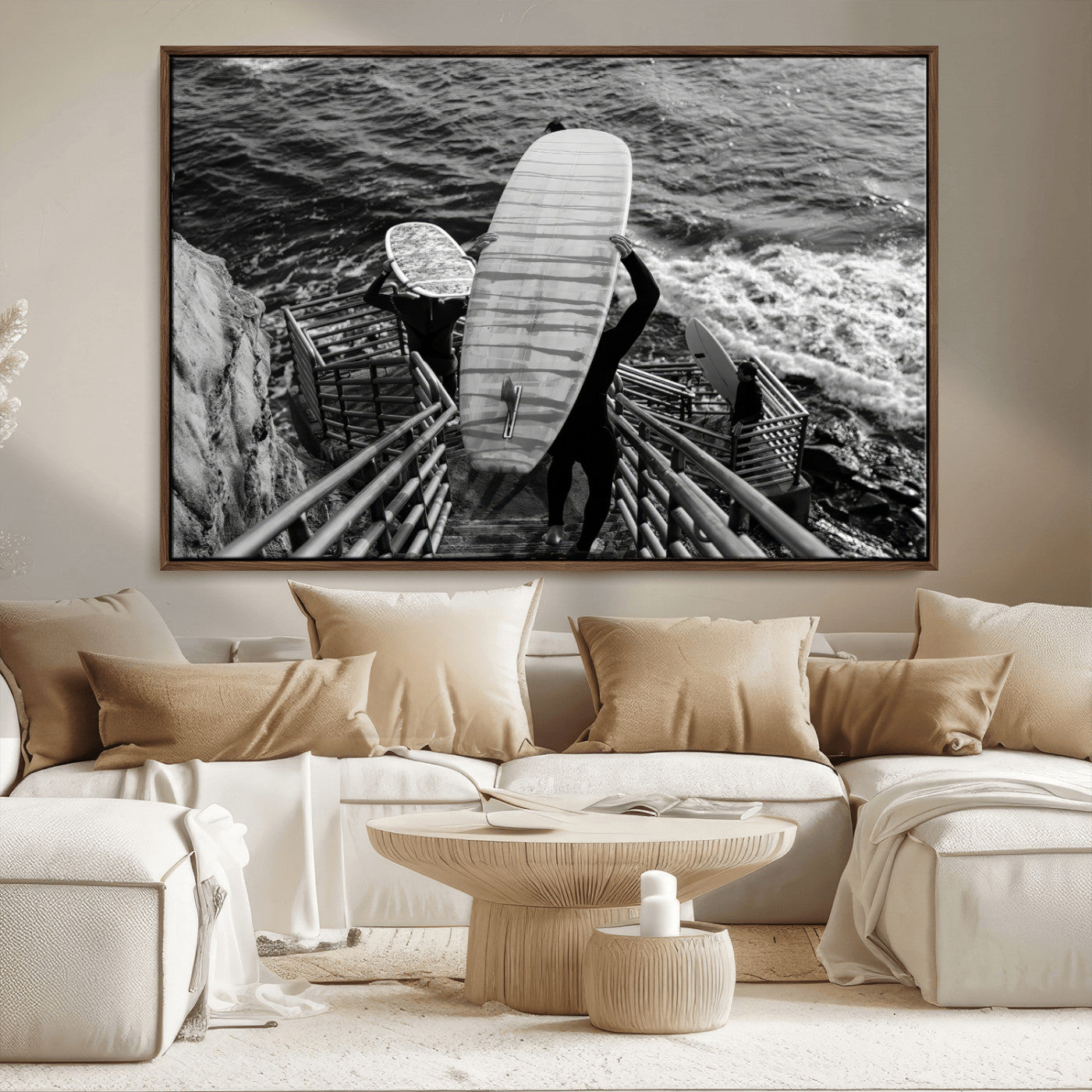 Black and white photo of surfers carrying boards down a rugged cliffside stairway, capturing a bold and adventurous coastal scene.