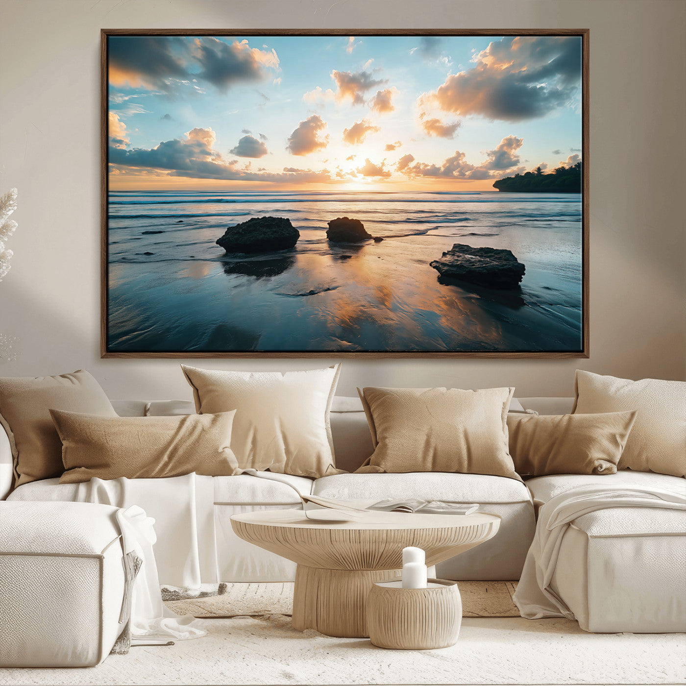 A serene beach at sunset with vibrant clouds, calm water, and rocks in the foreground reflecting the warm colors of the setting sun.
