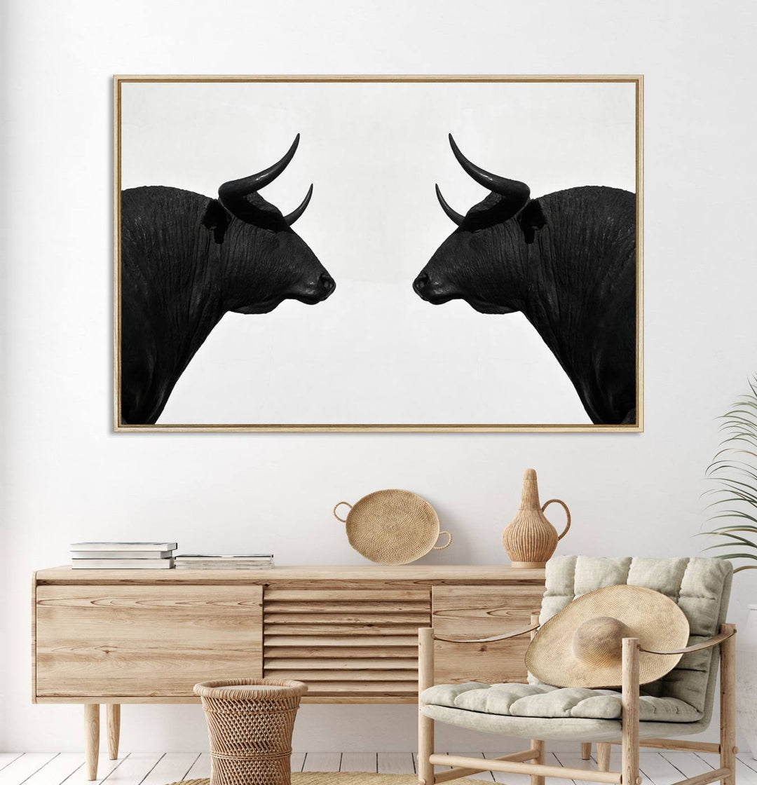 A framed canvas print featuring two black bull silhouettes, perfect for modern rustic decor.