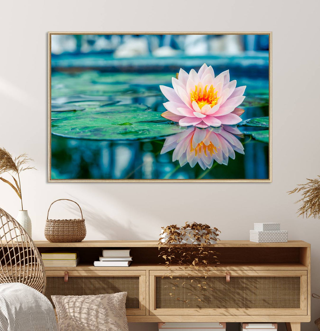 The Lotus Flower Canvas Print showcases a pink water lily with a yellow center gracefully floating on a calm pond.