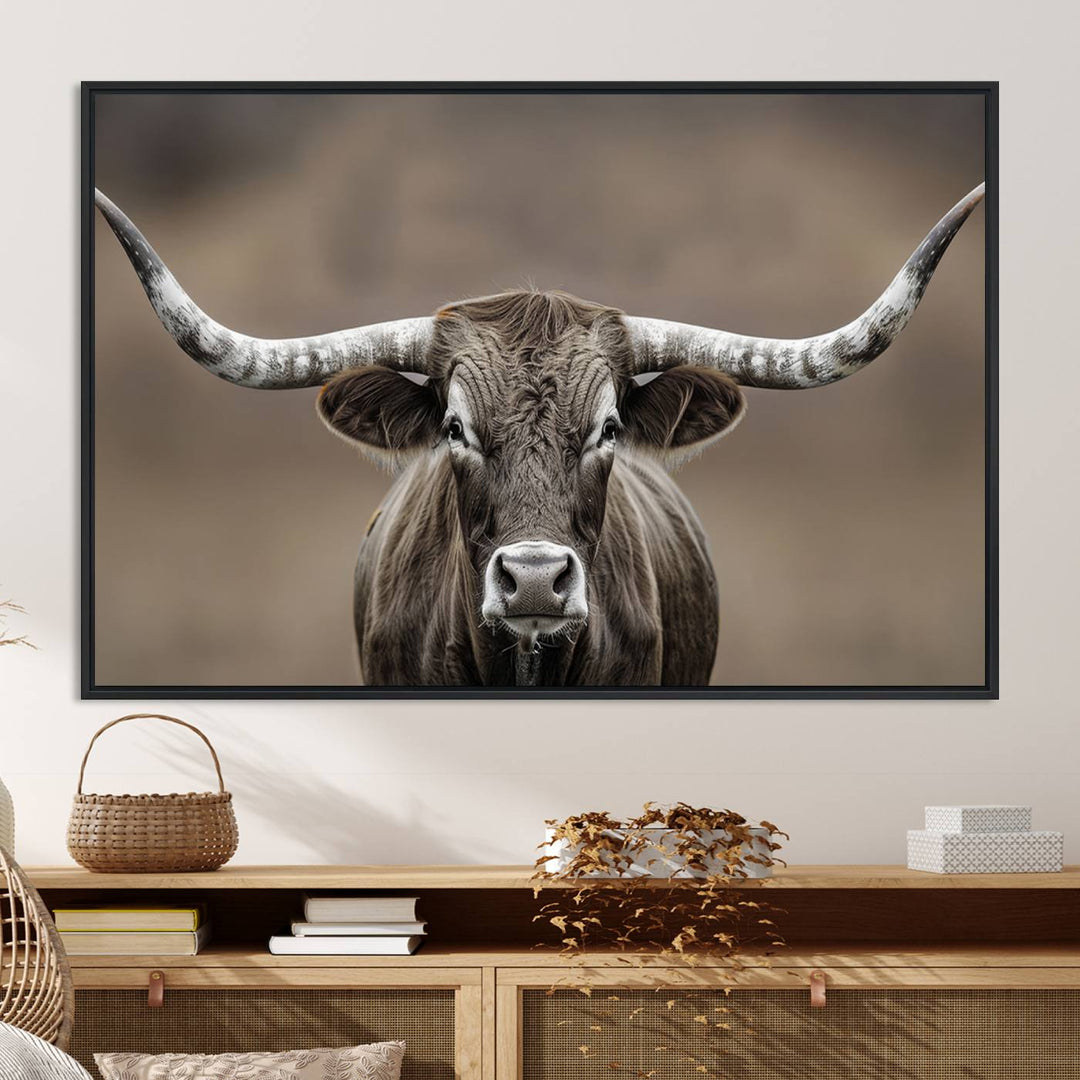 A close-up of a longhorn bull facing forward is featured in the Framed Texas Test-1, set against a blurred brown background.