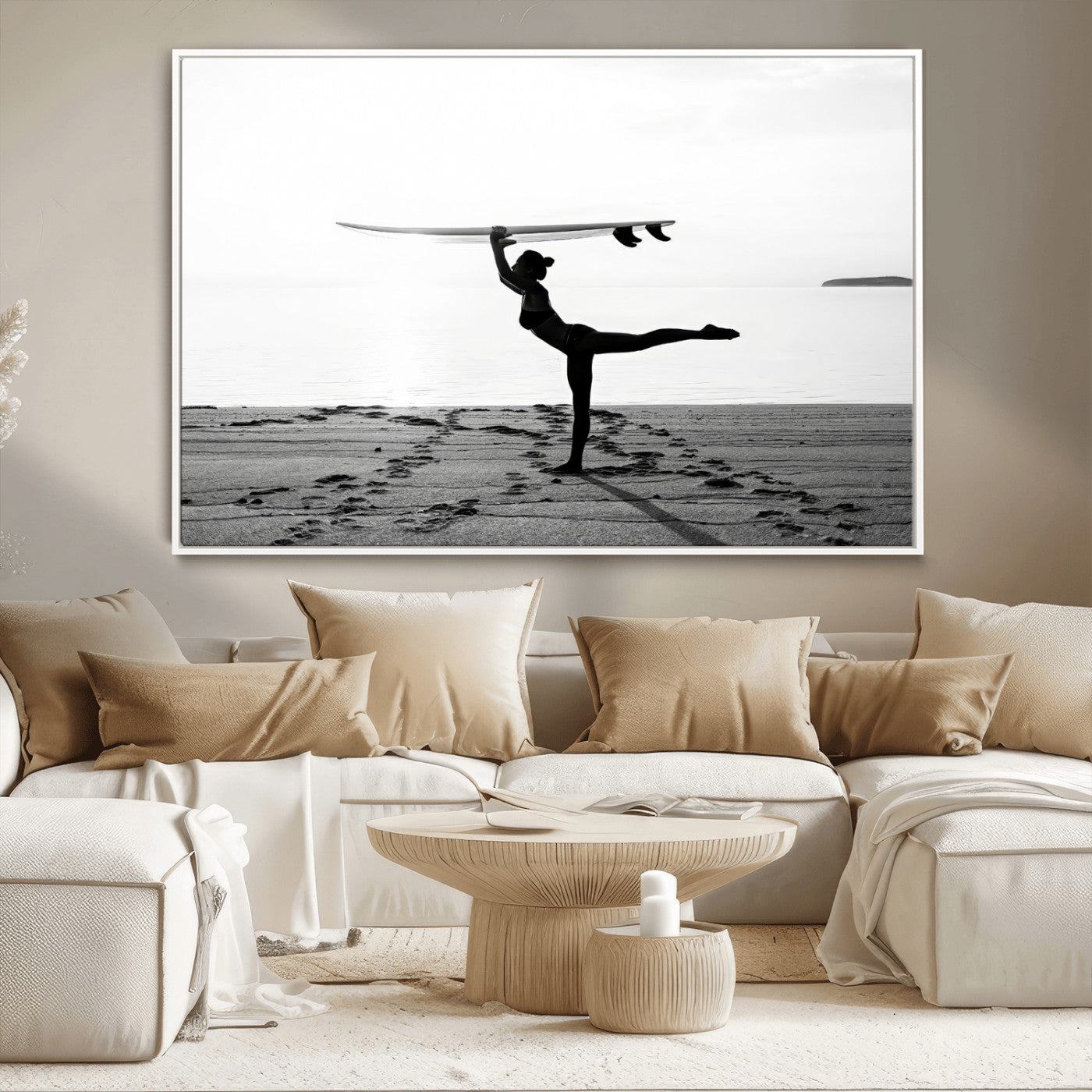 A woman balances a surfboard on her head while striking a yoga pose on the beach, silhouetted against a calm ocean horizon.