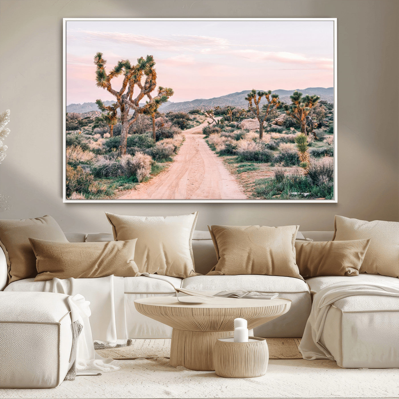 A dusty road winding through Joshua Tree National Park, framed by iconic twisted trees and warm desert tones under a soft pastel sky.