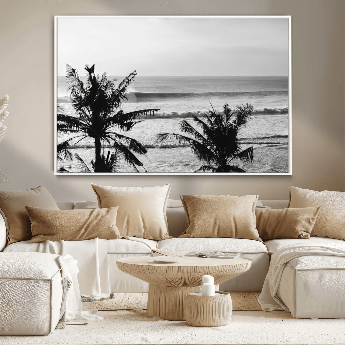 Black and white view of ocean waves crashing on a tropical coastline, framed by silhouetted palm trees under a vast, open sky.