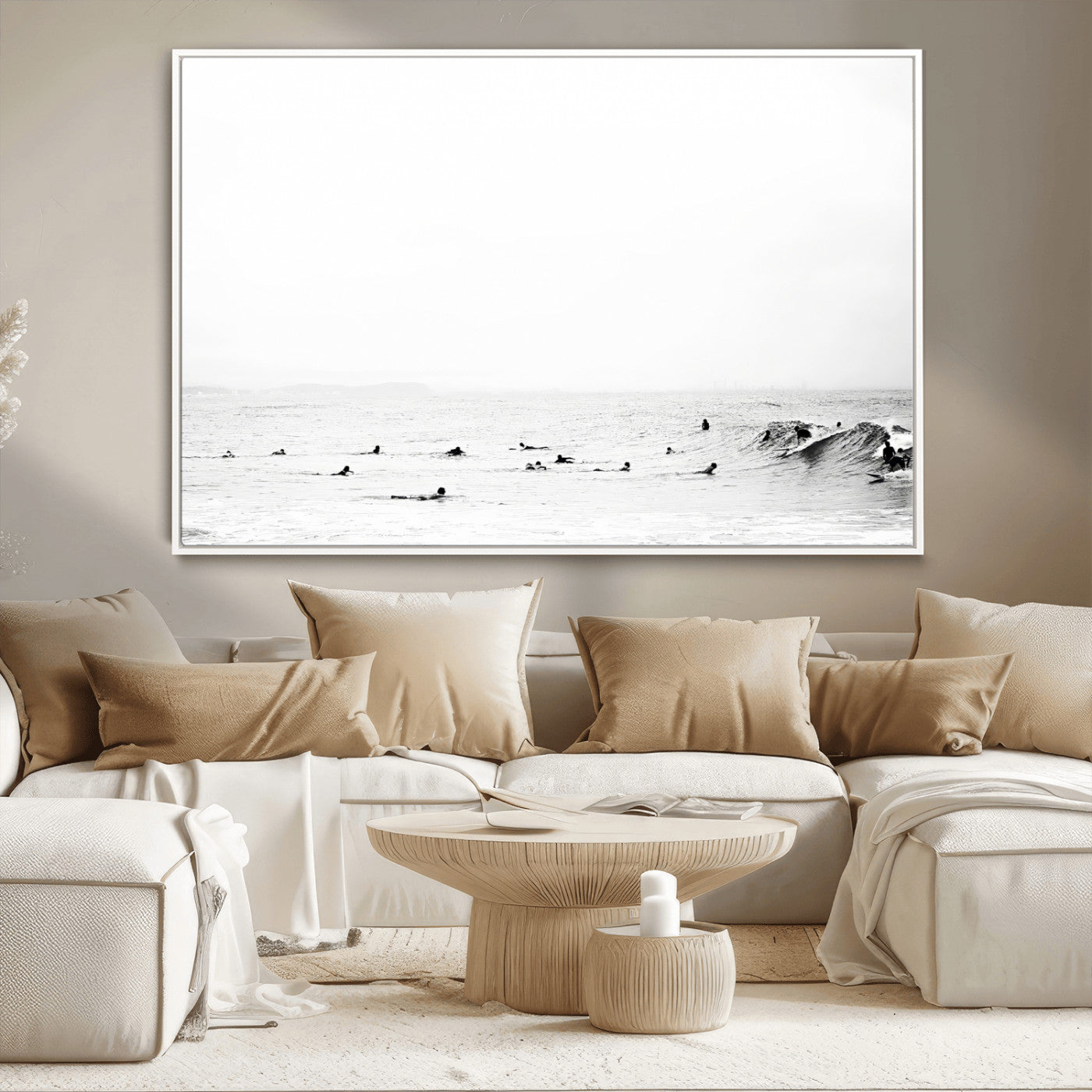 A group of surfers floating in the ocean, waiting for waves under a vast, moody sky, captured in black and white.