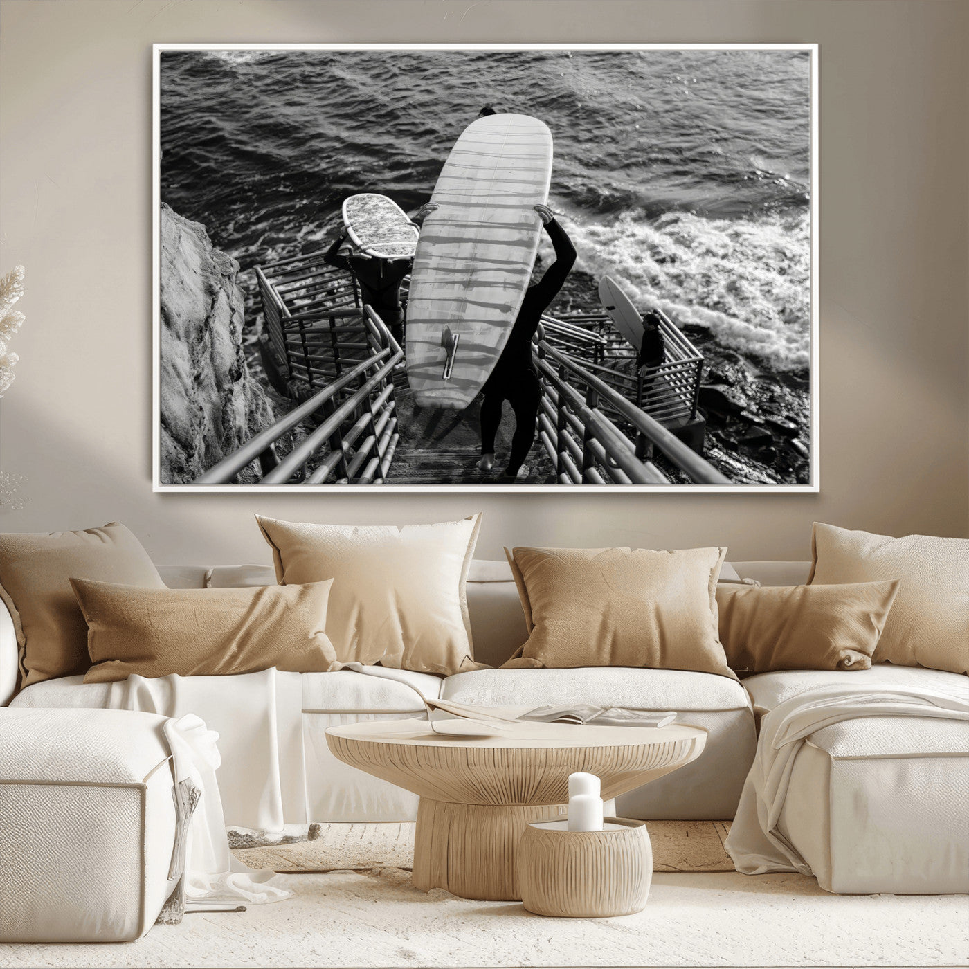 Black and white photo of surfers carrying boards down a rugged cliffside stairway, capturing a bold and adventurous coastal scene.