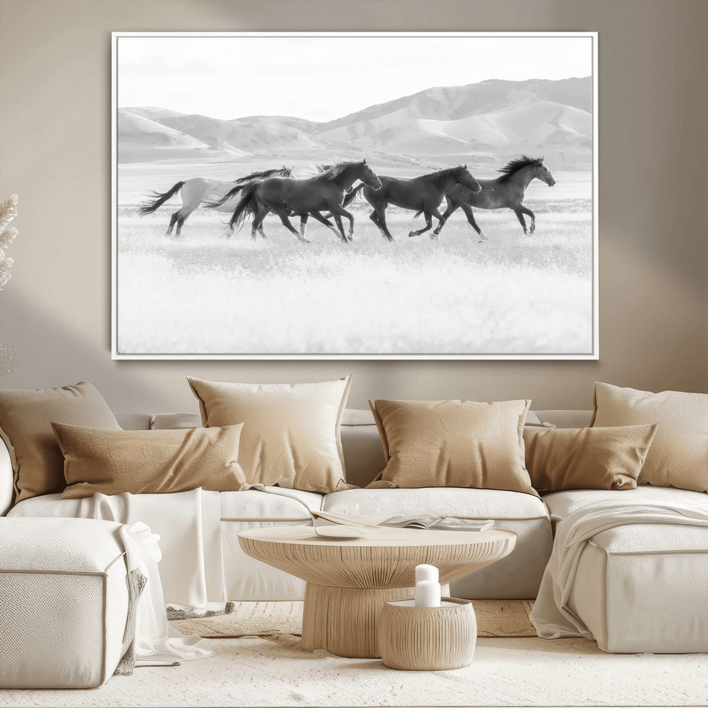 A black and white image of wild horses running freely across an open grassland, capturing the power and beauty of untamed nature in a rustic western setting.