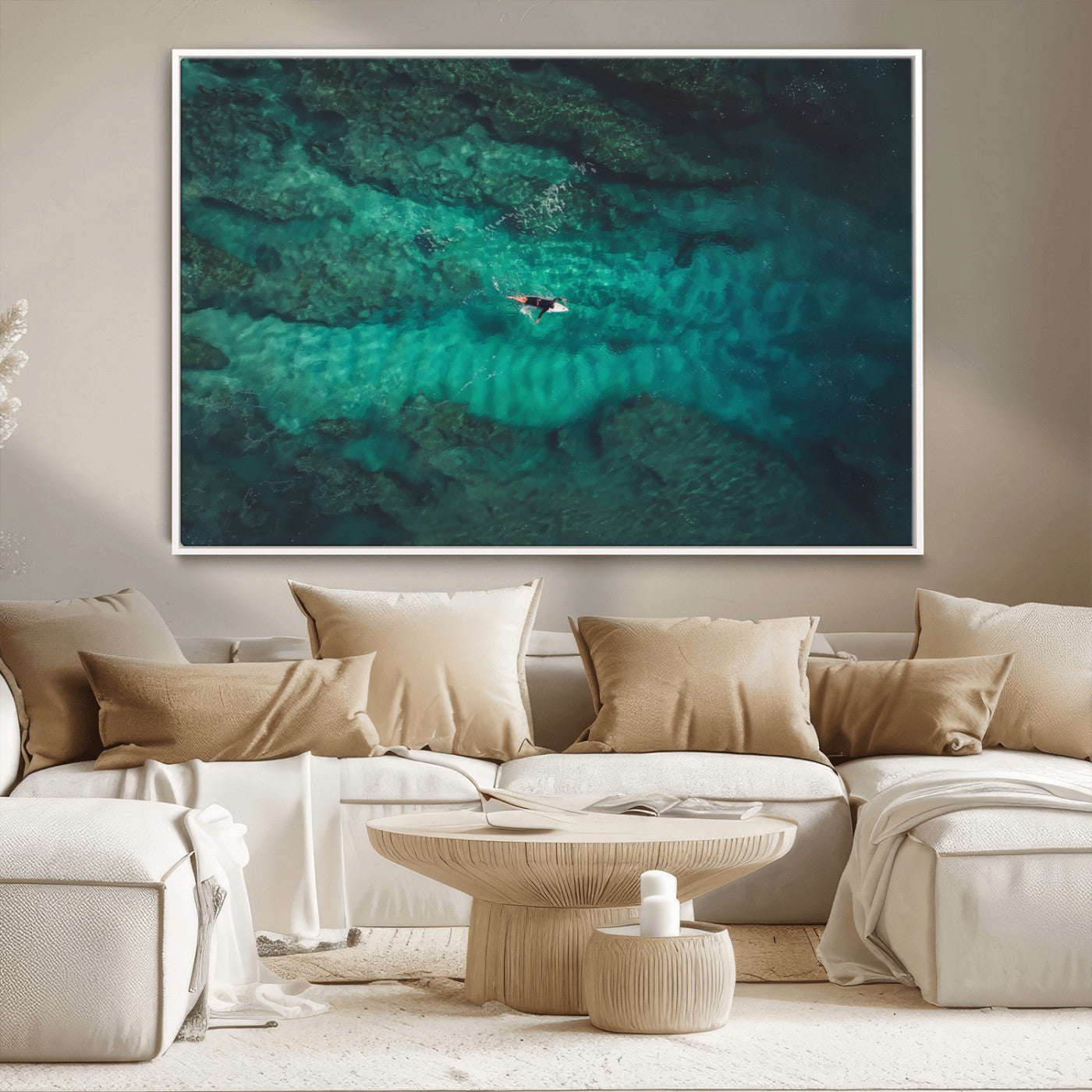 An aerial view of a solo surfer paddling through crystal-clear turquoise waters over a sunlit reef, capturing the beauty and serenity of open water surfing.