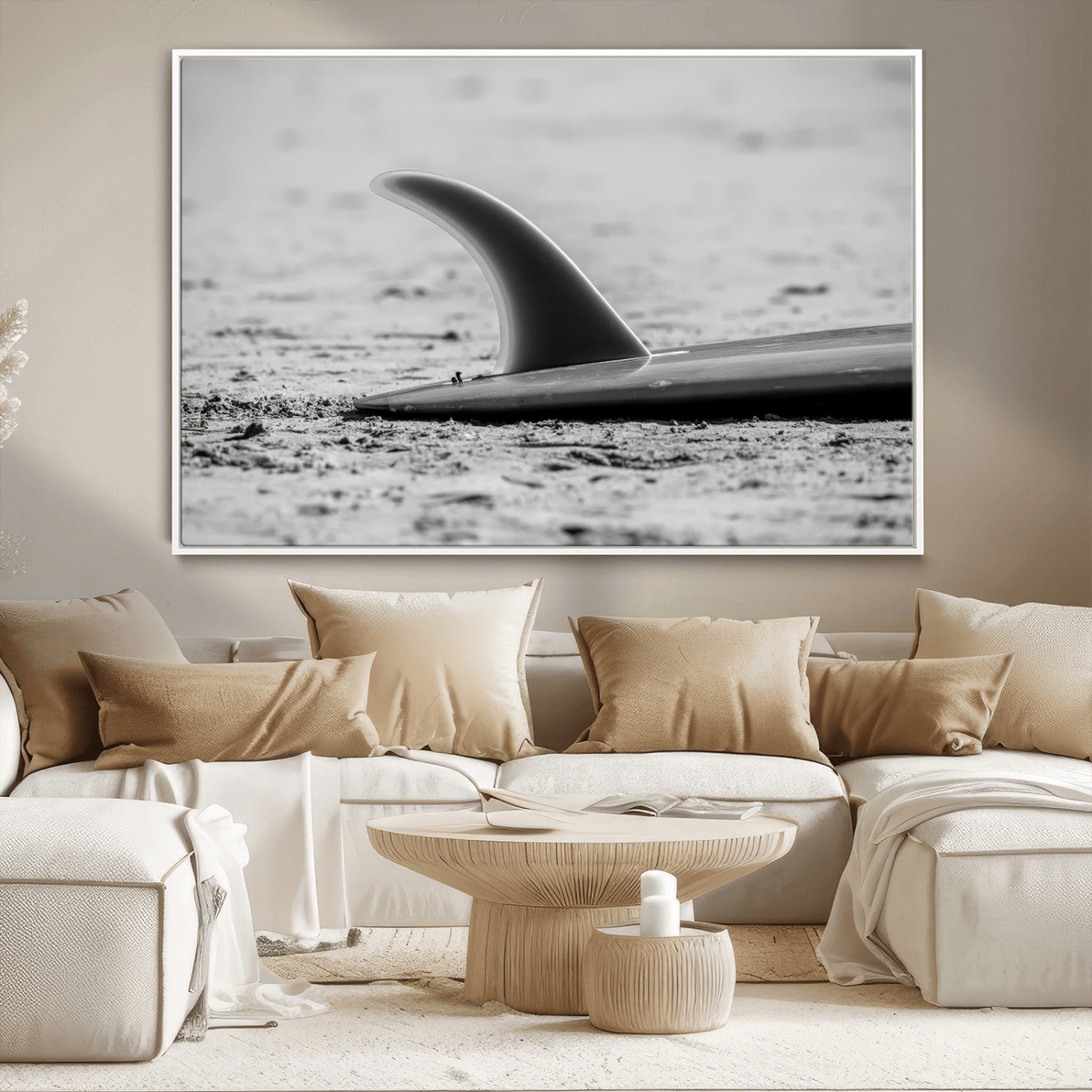 A black and white close-up of a surfboard fin resting on the sandy shore, highlighting minimalist beach aesthetics and classic surf culture.