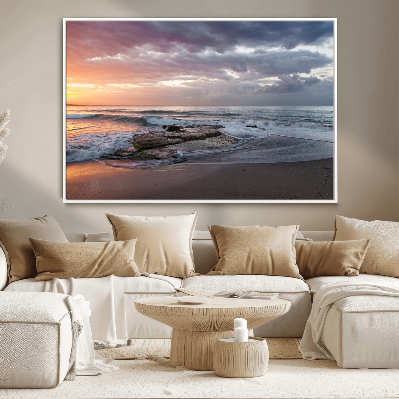 Dramatic sunset over a rocky shoreline with ocean waves gently reaching the sandy beach, creating a serene and coastal atmosphere.