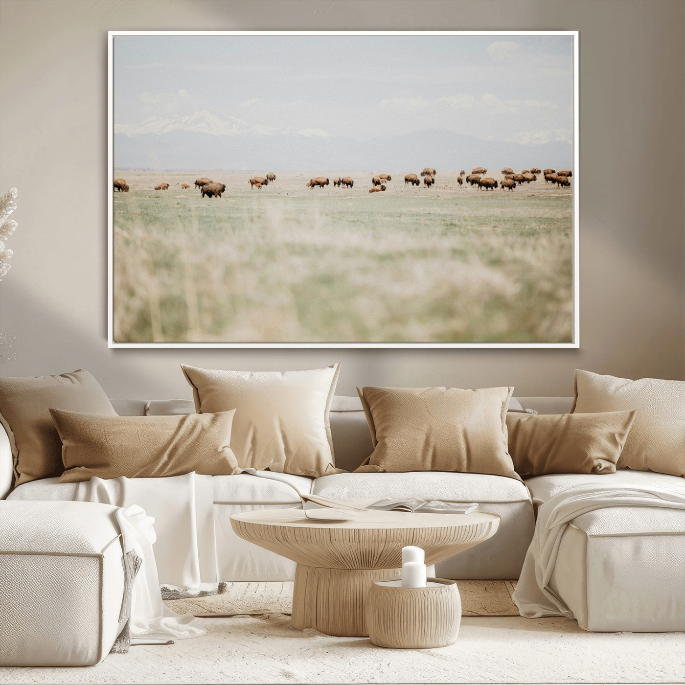 A herd of bison grazing in an open prairie with distant mountains under a soft sky, creating a serene and rustic Western landscape.