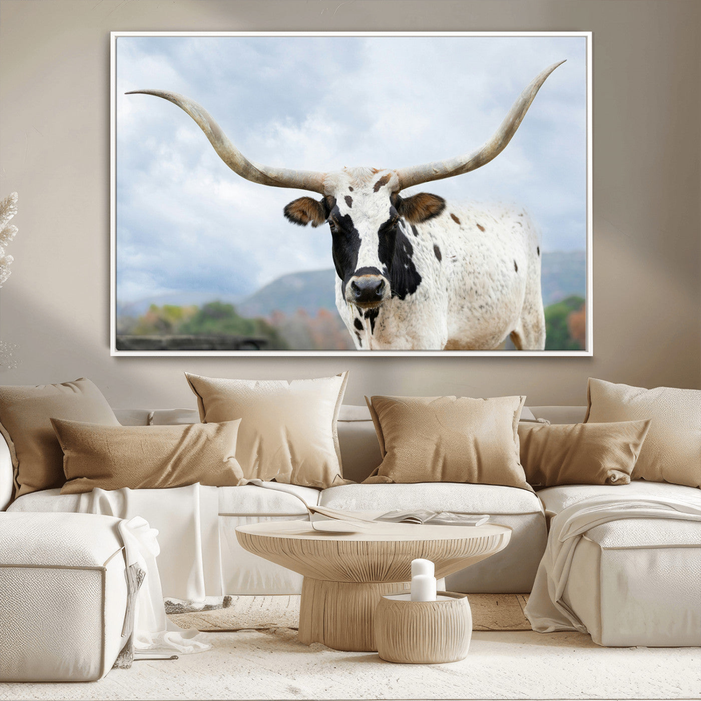 Close-up of a Texas Longhorn with curved horns, black and white markings, set against a cloudy sky and distant hills, perfect for rustic decor.