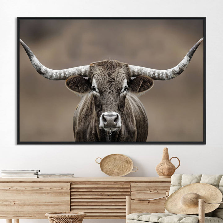 A close-up of a longhorn bull facing forward is featured in the Framed Texas Test-1, set against a blurred brown background.