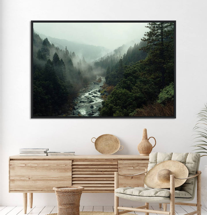 The Misty Forest Wall Art features a serene landscape with a misty river and evergreens, ideal for enhancing the ambiance of any living room or cabin.