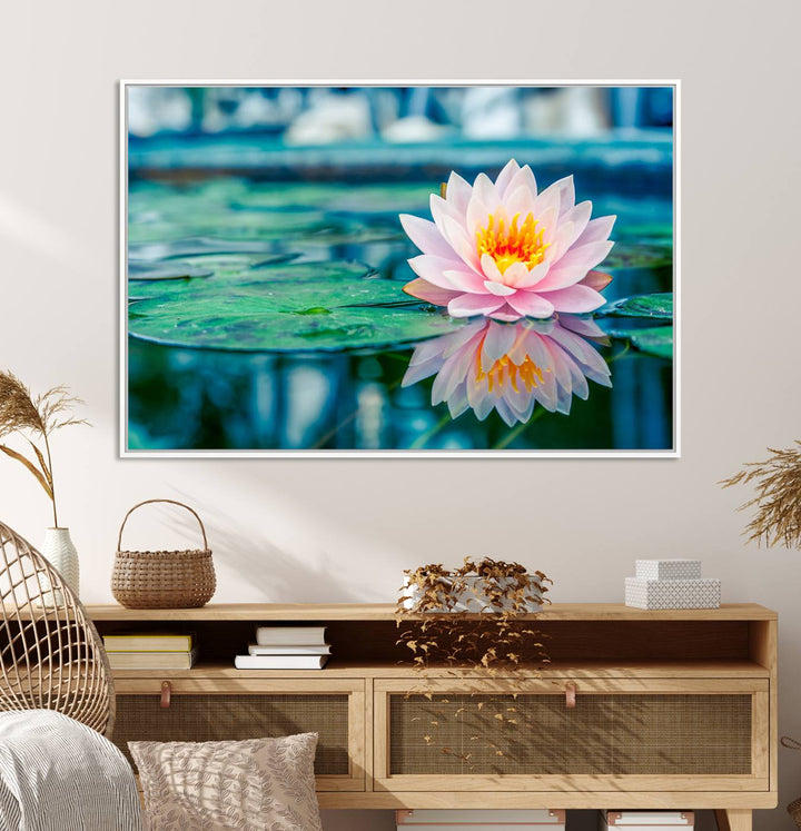 The Lotus Flower Canvas Print showcases a pink water lily with a yellow center gracefully floating on a calm pond.