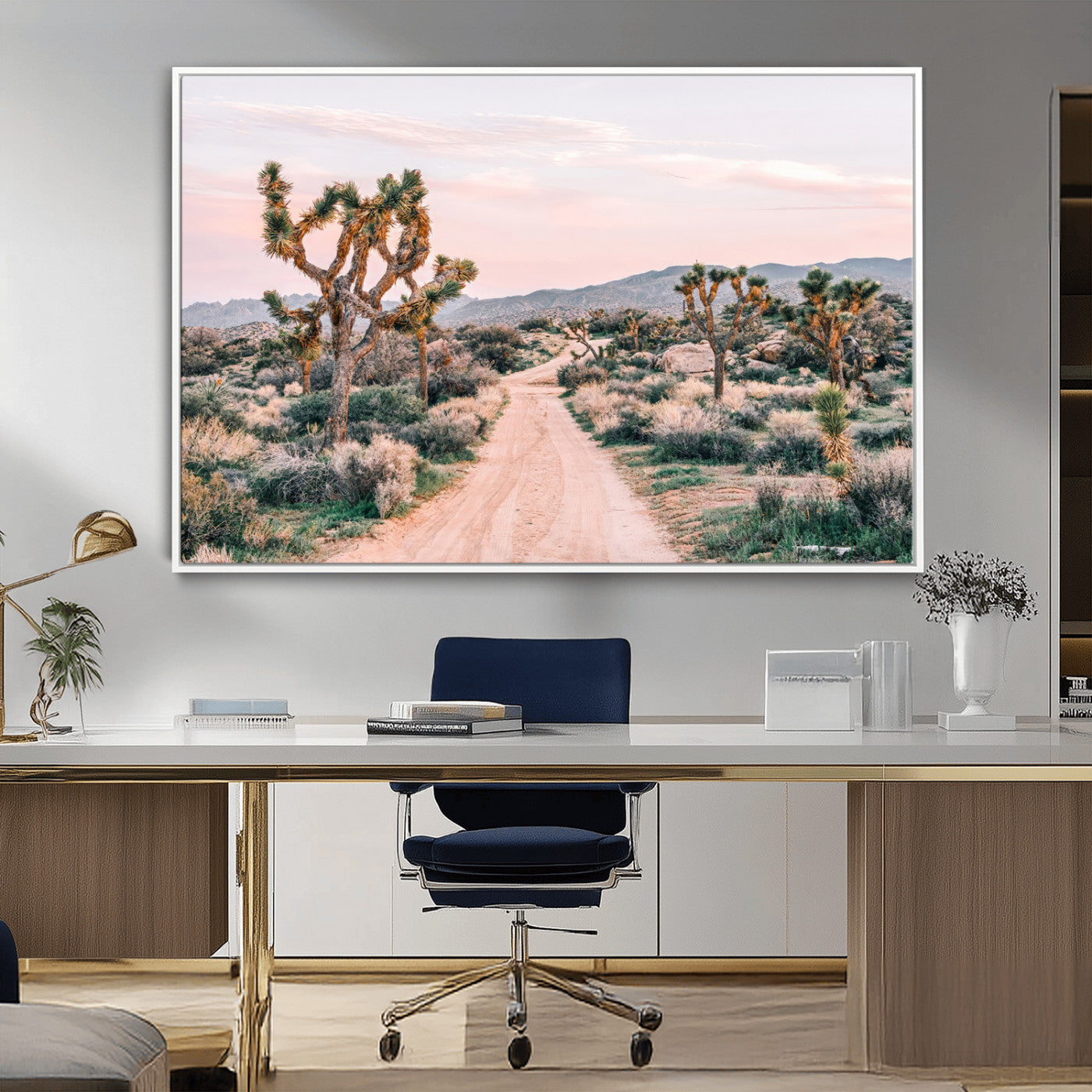 A dusty road winding through Joshua Tree National Park, framed by iconic twisted trees and warm desert tones under a soft pastel sky.