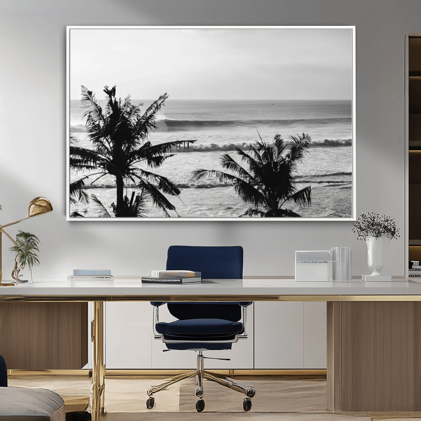 Black and white view of ocean waves crashing on a tropical coastline, framed by silhouetted palm trees under a vast, open sky.