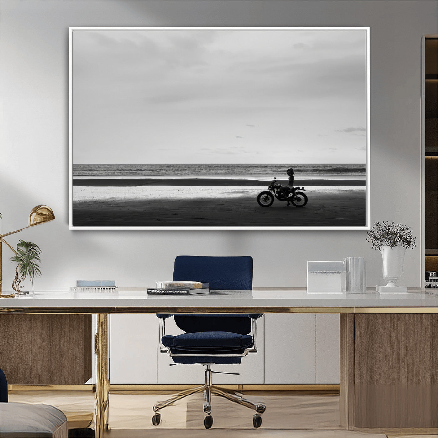 A motorcyclist on a vast beach, gazing at the ocean, capturing a moody and tranquil coastal adventure in black and white.