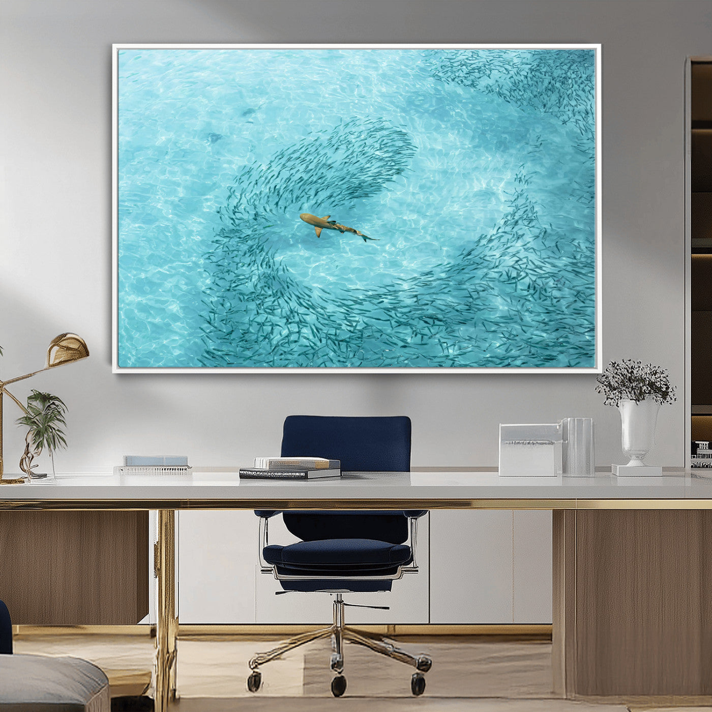 Aerial view of a shark swimming through a swirl of fish in clear turquoise waters, perfect for calm coastal or beach house decor.