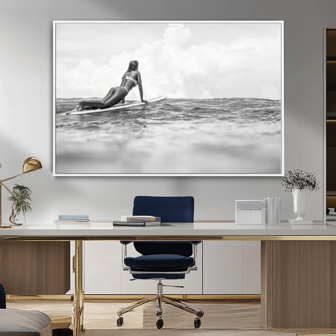 A black and white ocean scene featuring a surfer girl waiting on her board, gazing at the horizon, capturing a tranquil and adventurous coastal moment.