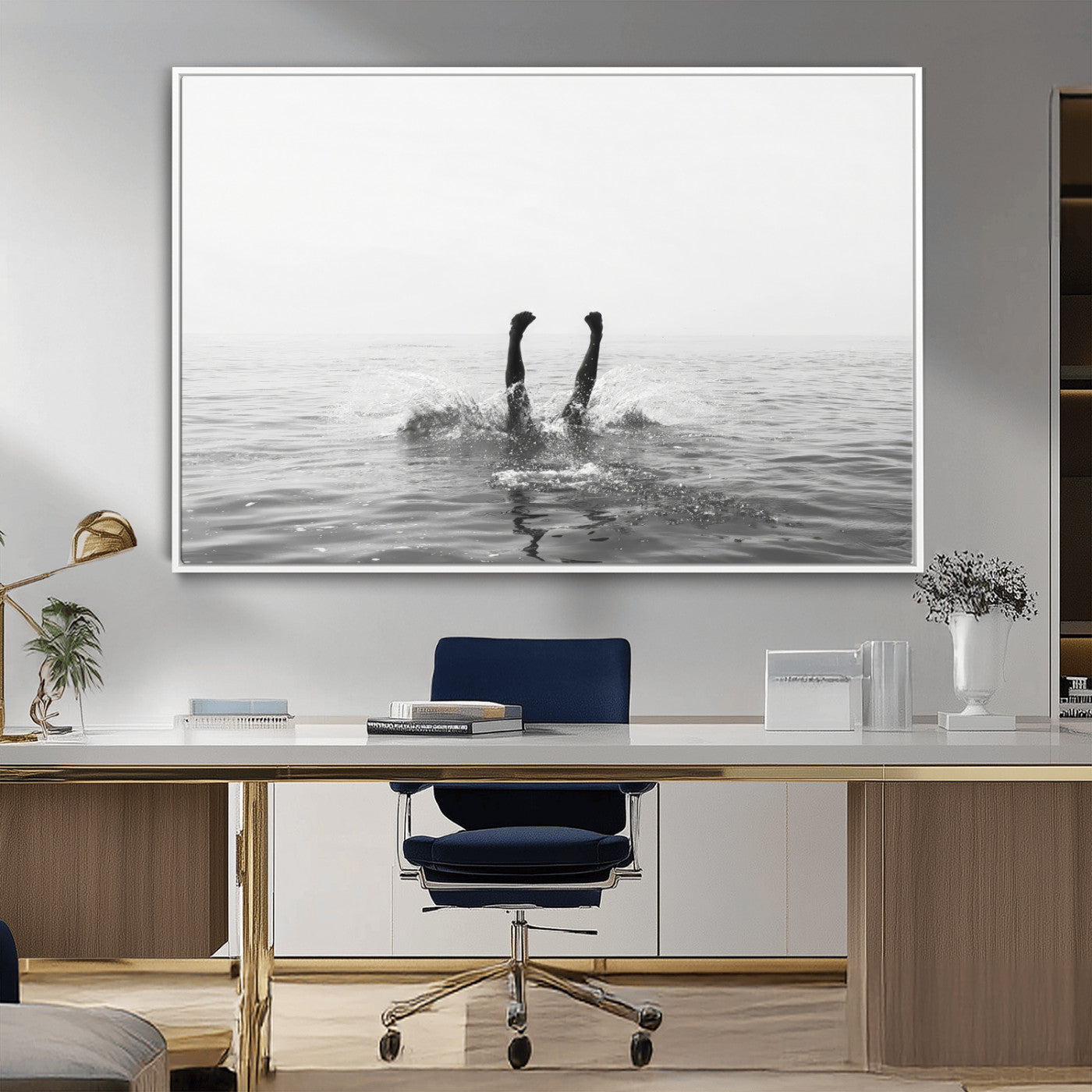 A black and white minimalist water scene capturing a playful splash as a swimmer dives upside down, creating a carefree and artistic aquatic aesthetic.