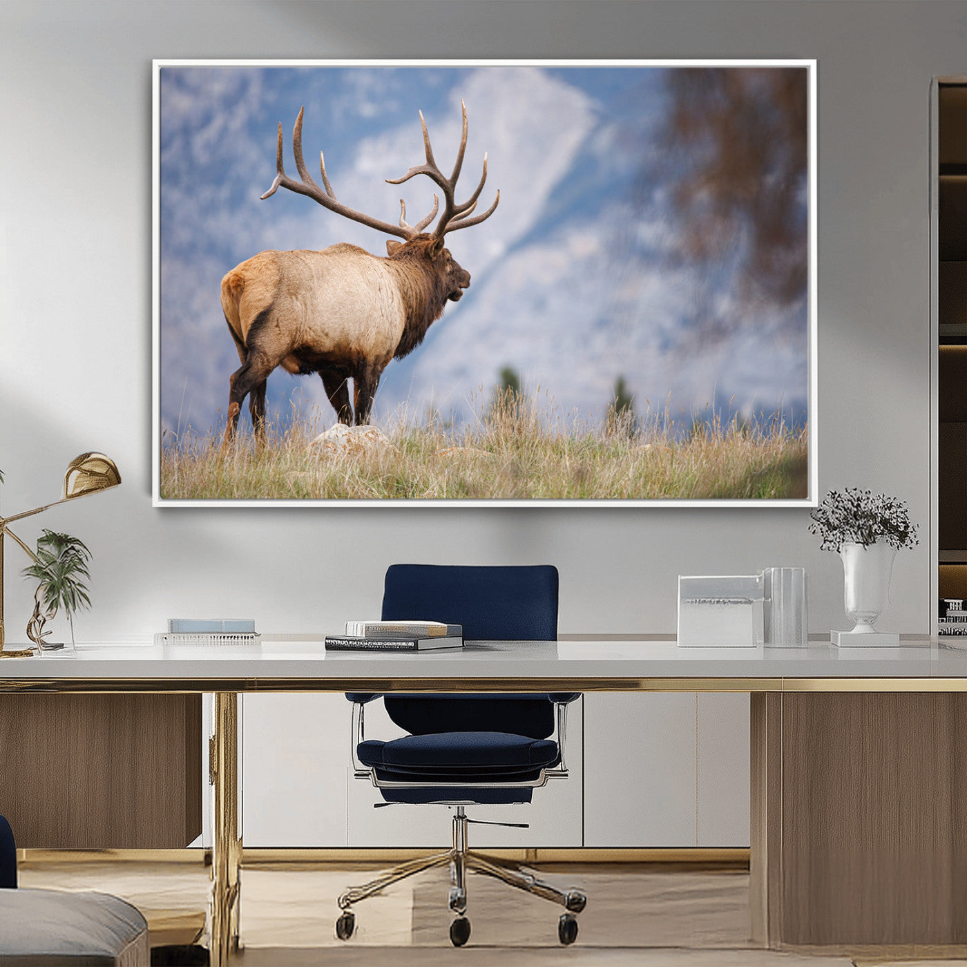 Elk with antlers standing on grass with mountain background, ideal for rustic, cabin, or lodge-inspired wall decor.