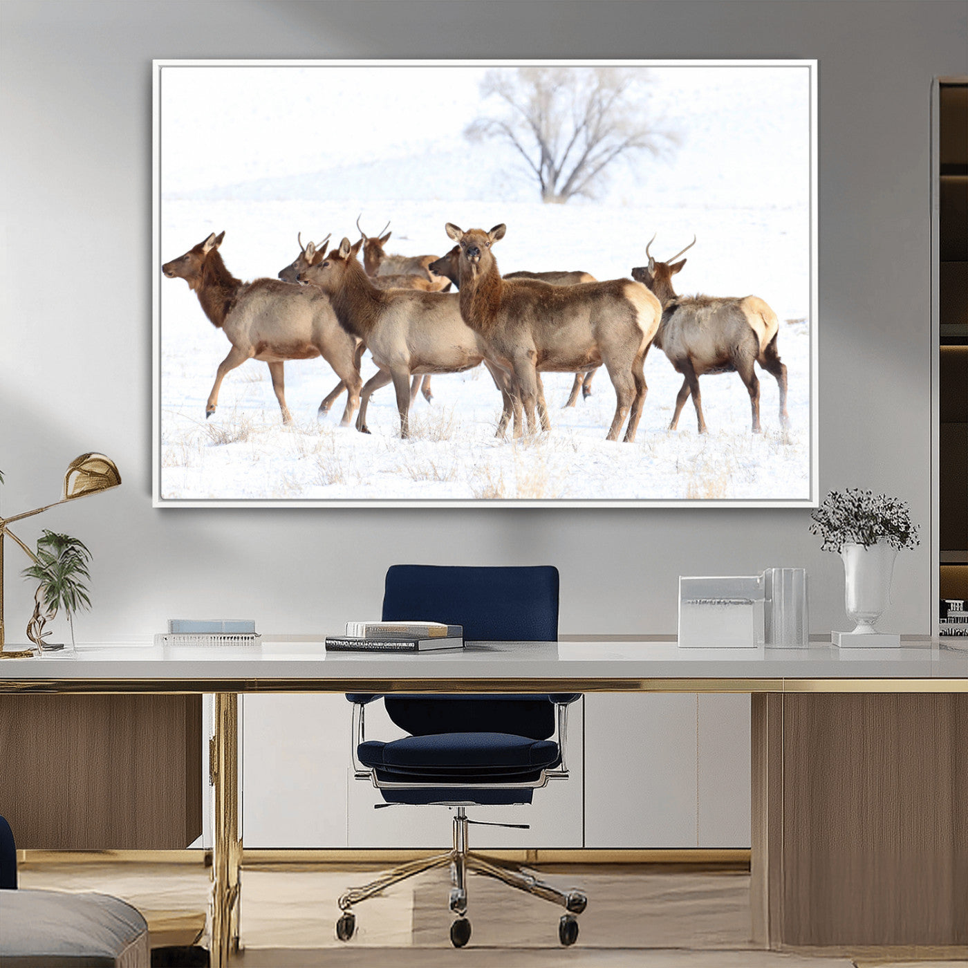 A group of elk standing on snowy terrain with a tree in the background, perfect for rustic or lodge-style winter wall decor.