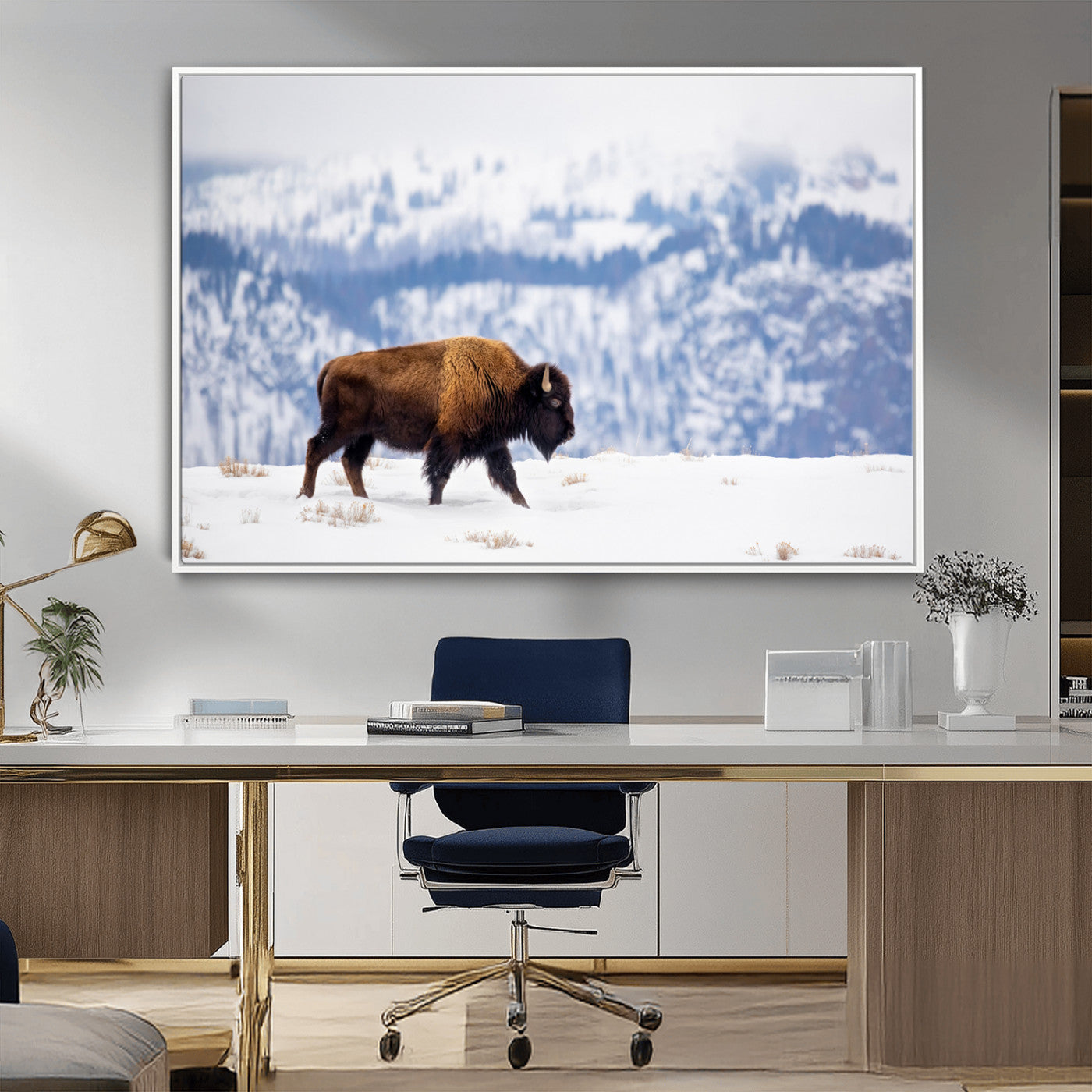 A lone bison walks across snowy ground with blue-toned mountain range behind, ideal for rustic or western farmhouse interiors.