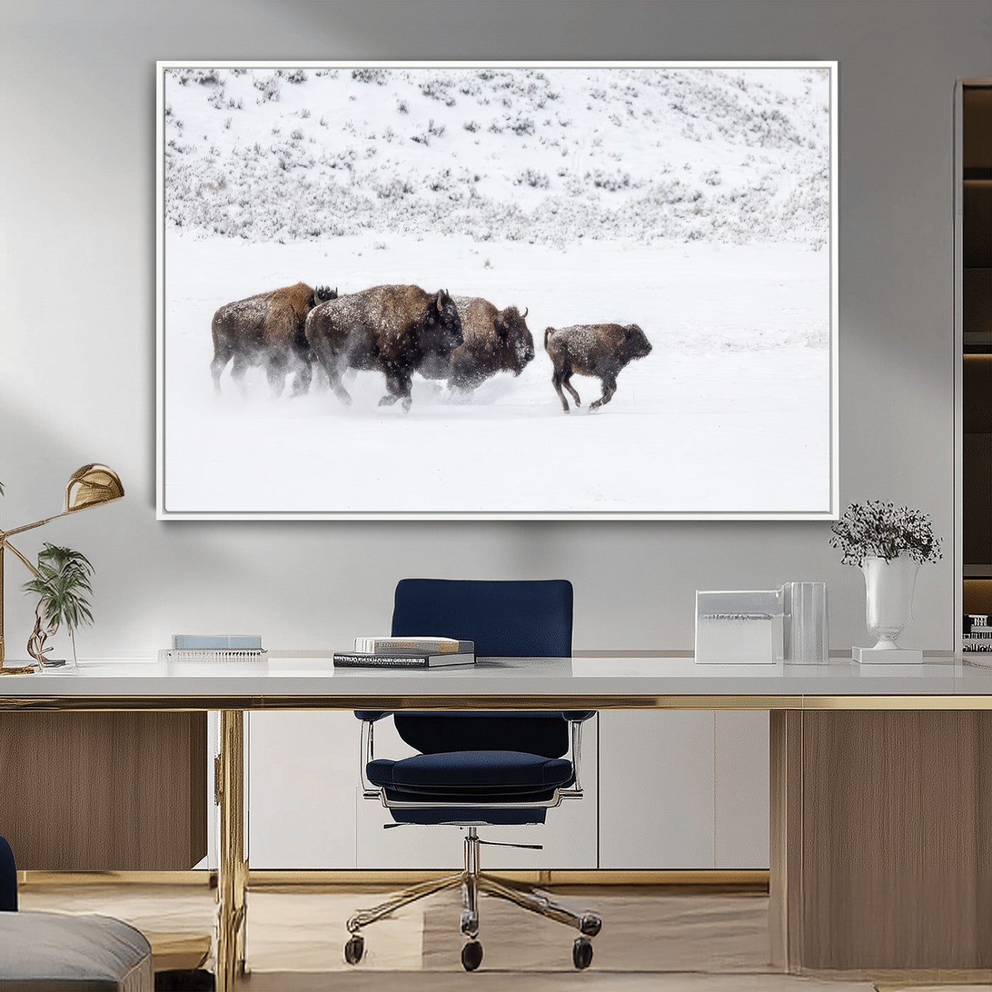 Bison herd running through a snowy open field with mountain backdrop, perfect for rustic or western-themed wall decoration.