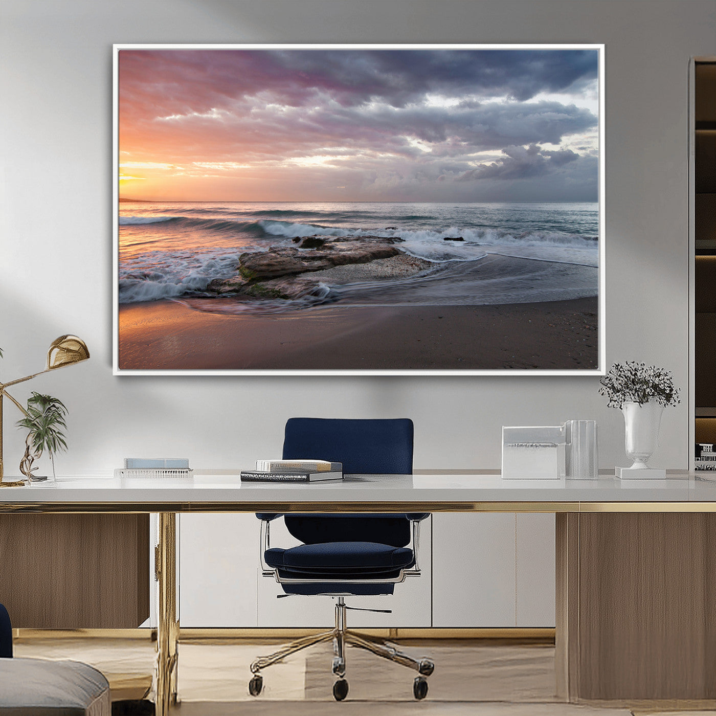 Dramatic sunset over a rocky shoreline with ocean waves gently reaching the sandy beach, creating a serene and coastal atmosphere.