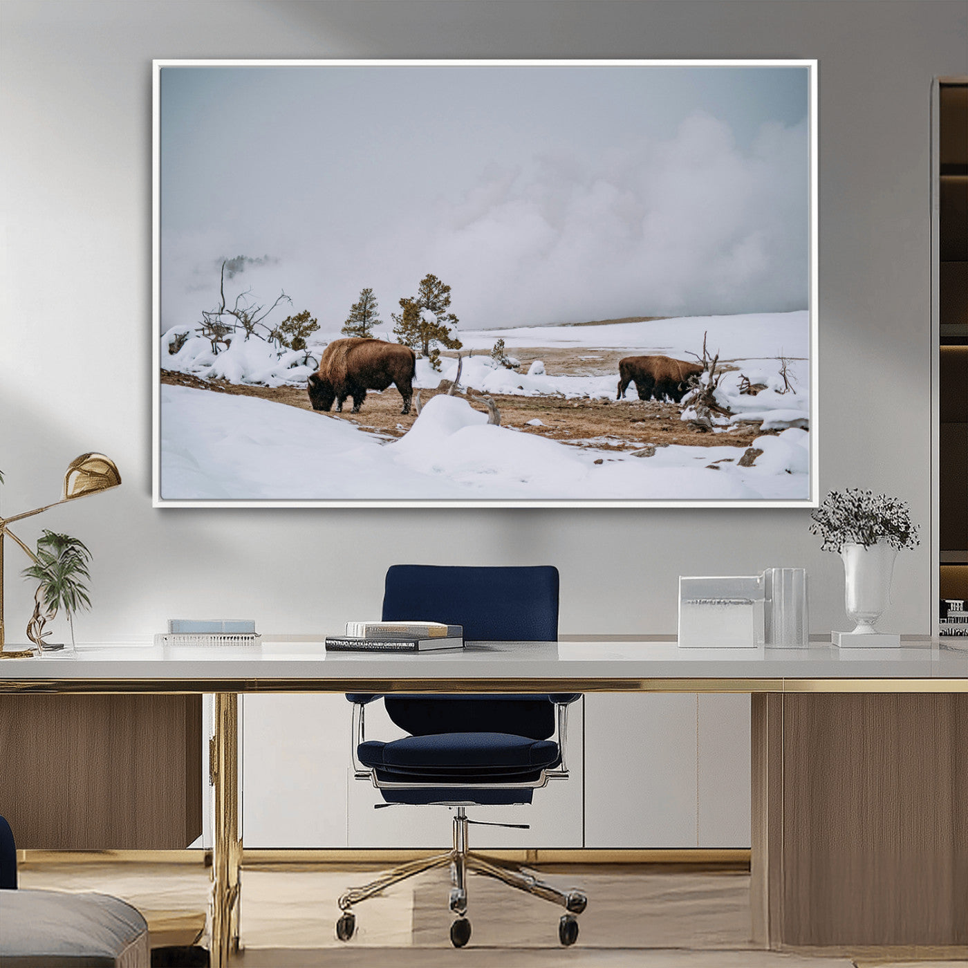 Two bison grazing in a snowy open landscape with misty hills in the background, creating a peaceful and rustic winter scene.