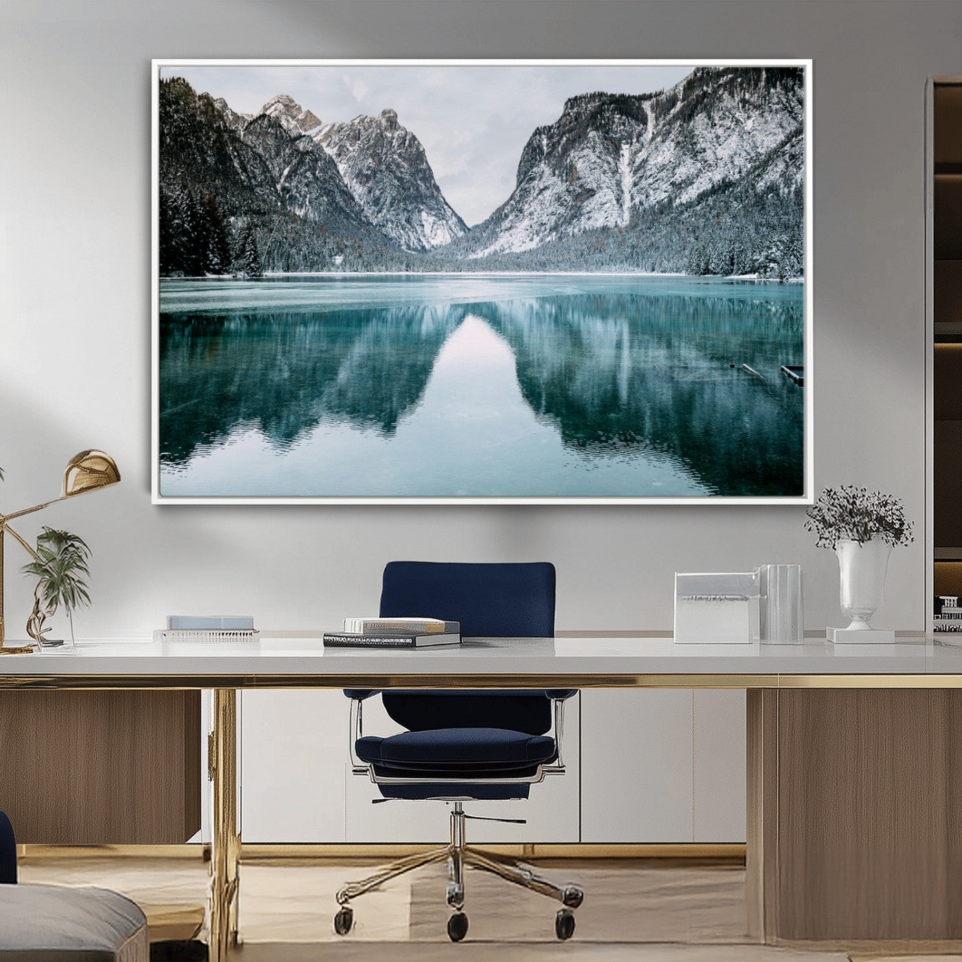 Crystal-clear alpine lake reflecting snow-covered mountains, surrounded by evergreen trees, creating a serene and tranquil winter landscape.