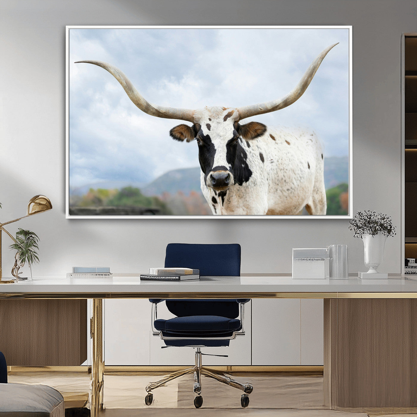 Close-up of a Texas Longhorn with curved horns, black and white markings, set against a cloudy sky and distant hills, perfect for rustic decor.