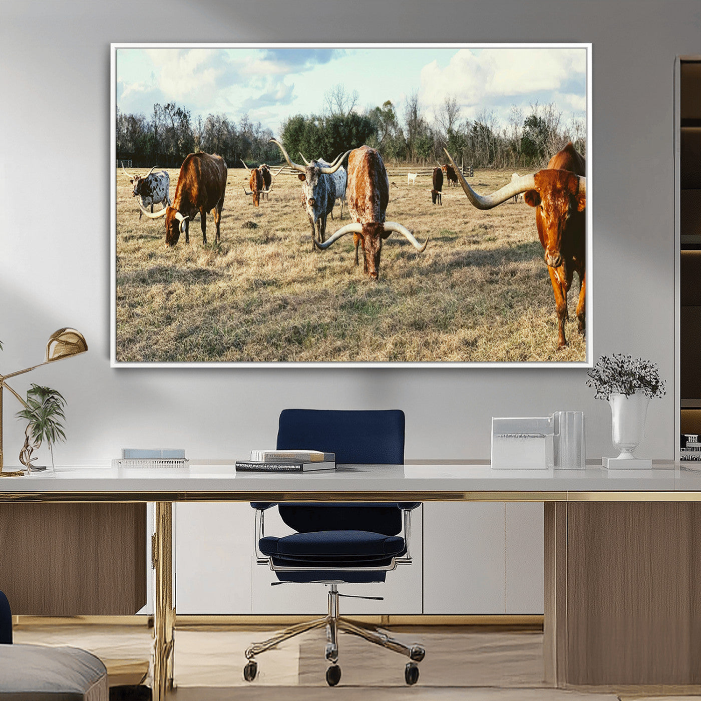 A herd of Texas Longhorn cattle grazing in an open field under a partly cloudy sky, capturing a rustic and Western ranch aesthetic.