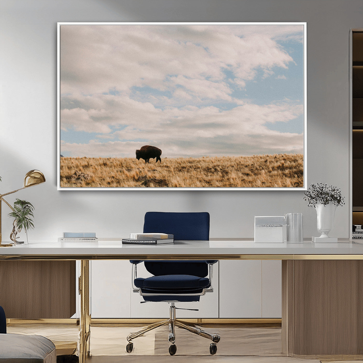 A solitary bison walking across a golden prairie under a vast, cloud-filled sky, evoking a peaceful, rustic western landscape for home decor.