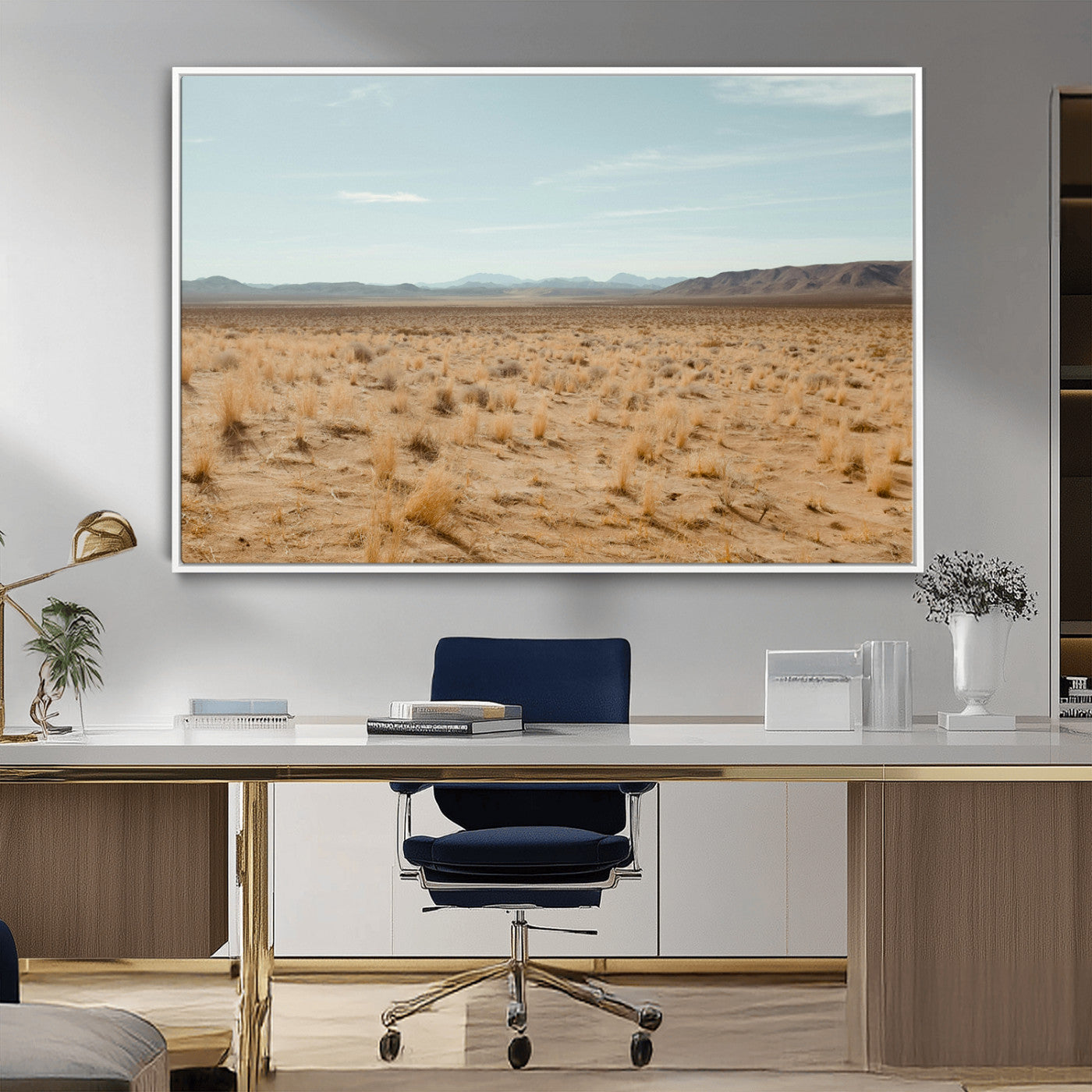 Expansive desert landscape with scattered dry grass and distant mountain range under a pale blue sky – Wall Art Canvas Print.